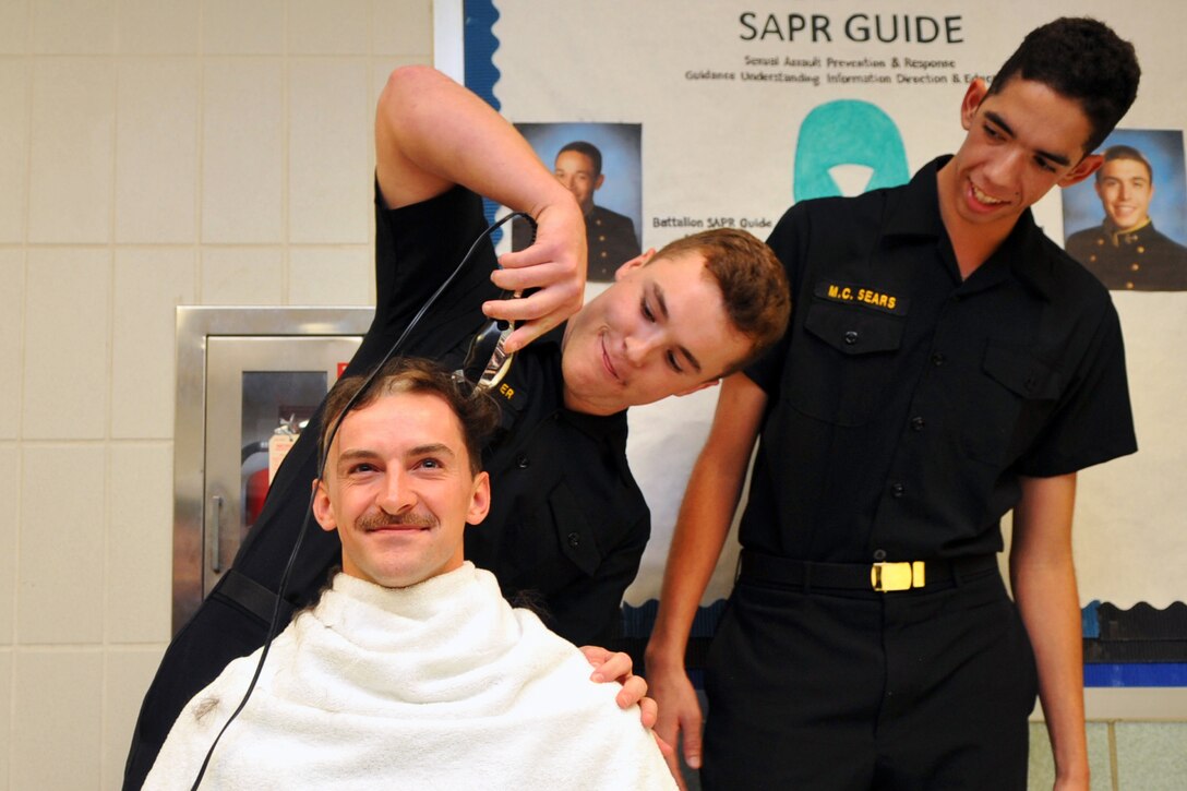 Navy Midshipman 1st Class Nicholas Martin recieves a buzz cut during a service selection ceremony in Bancroft Hall at the U.S. Naval Academy in Annapolis, Md., Nov. 19, 2015.  U.S. Navy photo by Petty Officer 2nd Class Tyler Caswell