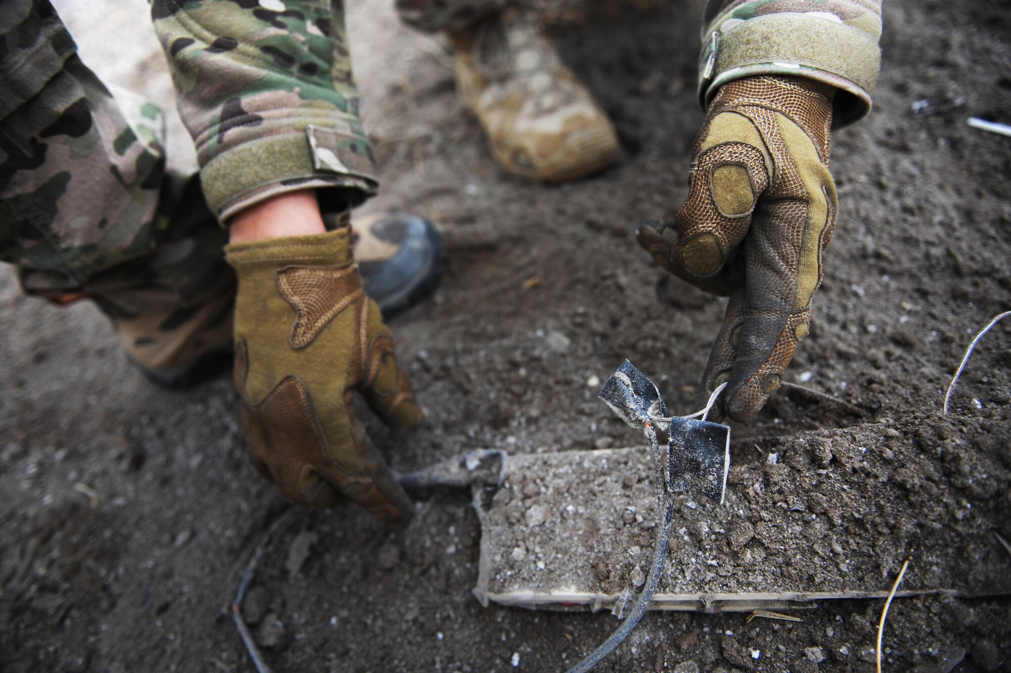 An Airman with the 775th Explosive Ordnance Disposal Flight examines wiring on a pressure plate used in an improvised explosive device during a training event at Hill Air Force Base, Utah, the training took place from Nov. 2-6, 2015.  Being an EOD technician requires Airmen to be adept in math, chemistry, forensics, mechanics, advanced electrical circuits and have the ability to put the knowledge to use under extreme pressure. (U.S. Air Force photo/Micah Garbarino)