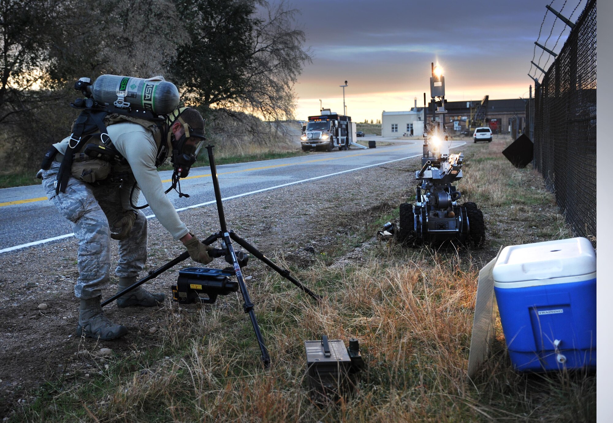 With the aid of lights and cameras on a remote-controlled robot, Senior Airman Garret Corbett, an explosive ordnance disposal technician with the 775th EOD Flight at Hill Air Force Base, sets up a mobile to examine the contents of a cooler during a training scenario on investigating suspicious packages. Once Corbett takes the X-ray, he can process them in a mobile computer lab in the command truck. (U.S. Air Force photo/Micah Garbarino)