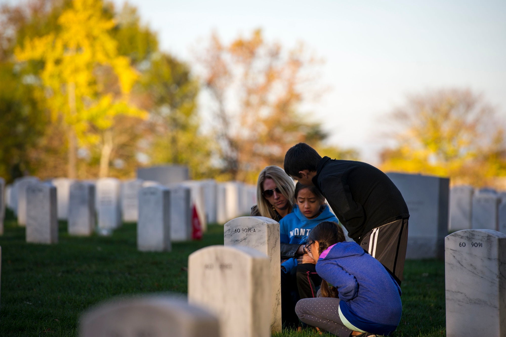 Heather Gray and her three children Ava (left), Garrett (middle) and Nyah visit Maj. David Gray at Arlington National Cemetery, Va., Nov. 11, 2015. David, a husband and father to the three children, was killed in action Aug. 8, 2012, during a deployment to Afghanistan. Heather and her children moved from Colorado, where David was stationed at Fort Carson, earlier this year for the first time since his death. (U.S. Air Force photo/Staff Sgt. Christopher Gross)