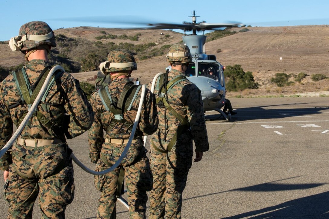 U.S. Marines with Golf Co., Battalion Landing Team 2/1, 13th Marine Expeditionary Unit (MEU), prepare to be lifted from the ground during Special Patrol Insertion and Extraction (SPIE) rigging training at Camp Pendleton, Calif., Nov. 19, 2015. SPIE rigging training prepares Marines for fast entry and exit from difficult and possibly dangerous combat areas. (U.S. Marine Corps photo by Cpl. Briauna Birl/RELEASED)