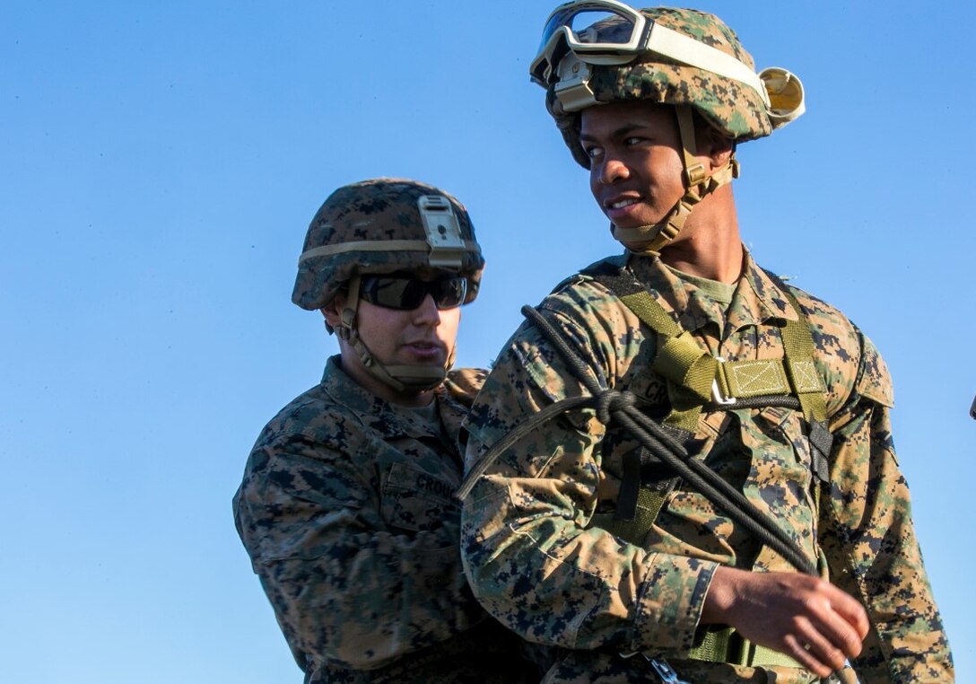 U.S. Marine Cpl. Allen Crouch and Cpl. Nigel Crowley with Golf Co., Battalion Landing Team 2/1, 13th Marine Expeditionary Unit (MEU), work together to ensure all knots are properly tied during Special Patrol Insertion and Extraction (SPIE) rigging training at Camp Pendleton, Calif., Nov. 19, 2015. SPIE rigging training prepares Marines for fast entry and exit from difficult and possibly dangerous combat areas. (U.S. Marine Corps photo by Cpl. Briauna Birl/RELEASED)
