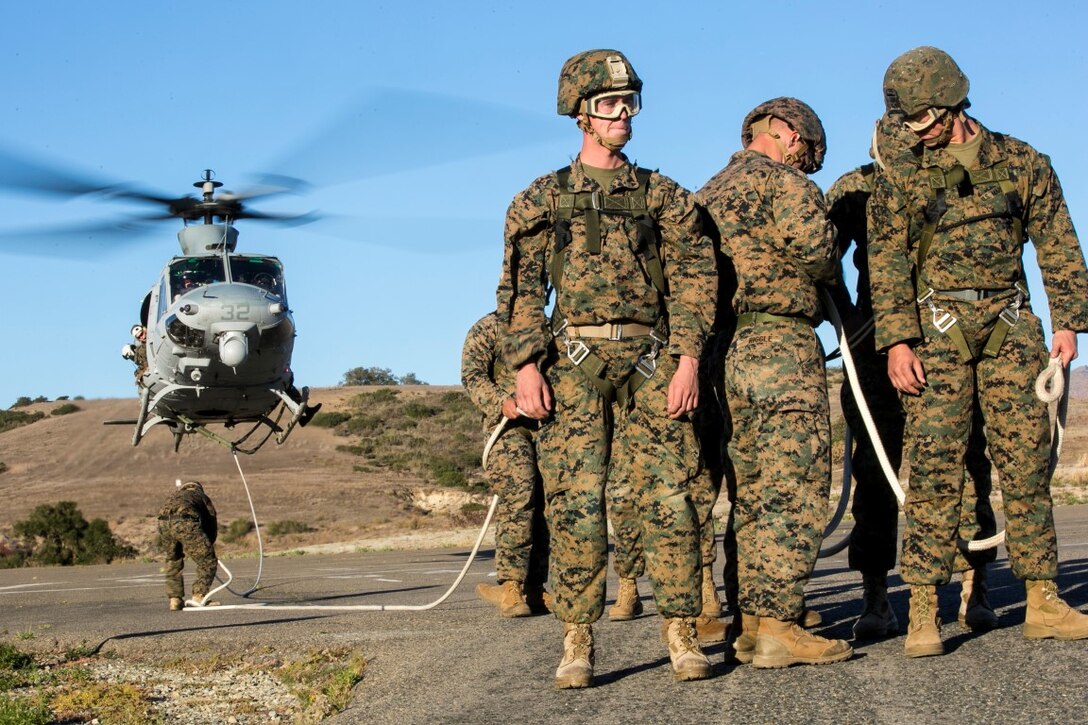 U.S. Marines with Golf Co., Battalion Landing Team 2/1, 13th Marine Expeditionary Unit (MEU), unhook from the rope after landing at the airfield during Special Patrol Insertion and Extraction (SPIE) rigging training at Camp Pendleton, Calif., Nov. 19, 2015. SPIE rigging training prepares Marines for fast entry and exit from difficult and possibly dangerous combat areas. (U.S. Marine Corps photo by Cpl. Briauna Birl/RELEASED)