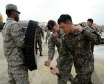 Staff Sgt. Aaron Robison, 51st Security Forces Squadron training instructor, teaches 1st Lt. James Park, Republic of Korea air force 3rd Training Wing special duty team, proper baton training during the combat readiness course on Osan Air Base, ROK, Nov. 17, 2015. The five-day course covers different spectrums of defense needed to support the mission such as non-lethal fighting, combatives, land navigation and active-shooter training. It is designed to teach or re-teach the defenders to perform communicative, tactical, and emergency procedures through simulated environments ensuring they're prepared for real-world contingencies. 