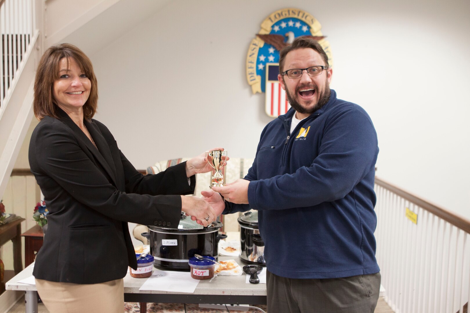 Dawn Bonsell, DLA Distribution Public Affairs Officer, presents Matt Williams, DLA Future Plans, with his trophy for “people’s choice.”