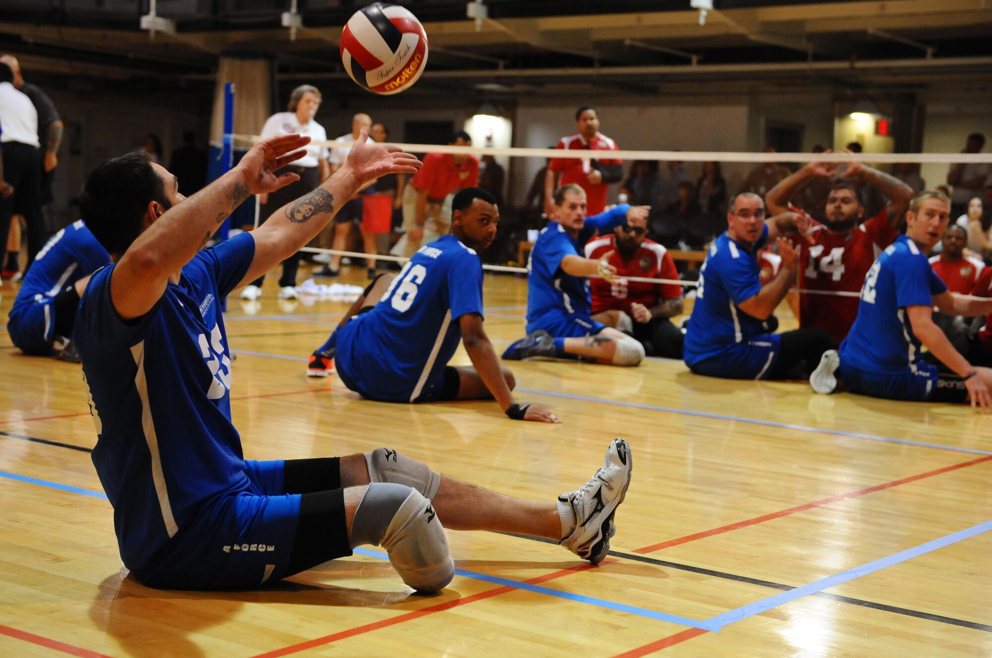 Retired Staff Sgt. Nicholas Dadgostar serves the ball during the Warrior Care Month Sitting Volleyball Tournament championship game at the Pentagon in Washington, D.C., Nov. 19, 2015. The Air Force won the tournament by beating the Marines. (U.S. Air Force photo/Senior Airman Hailey Haux)