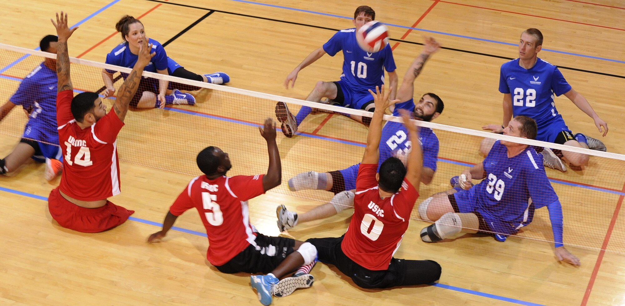 A member of the Air Force wounded warrior volleyball team spikes the ball during a volleyball match as part of the Warrior Care Month Sitting Volleyball Tournament at the Pentagon in Washington, D.C., Nov. 19, 2015. The Air Force Wounded Warrior Team won the match against the Marines, and went on to take home the trophy for the tournament. (U.S. Air Force photo/Staff Sgt. Whitney Stanfield)