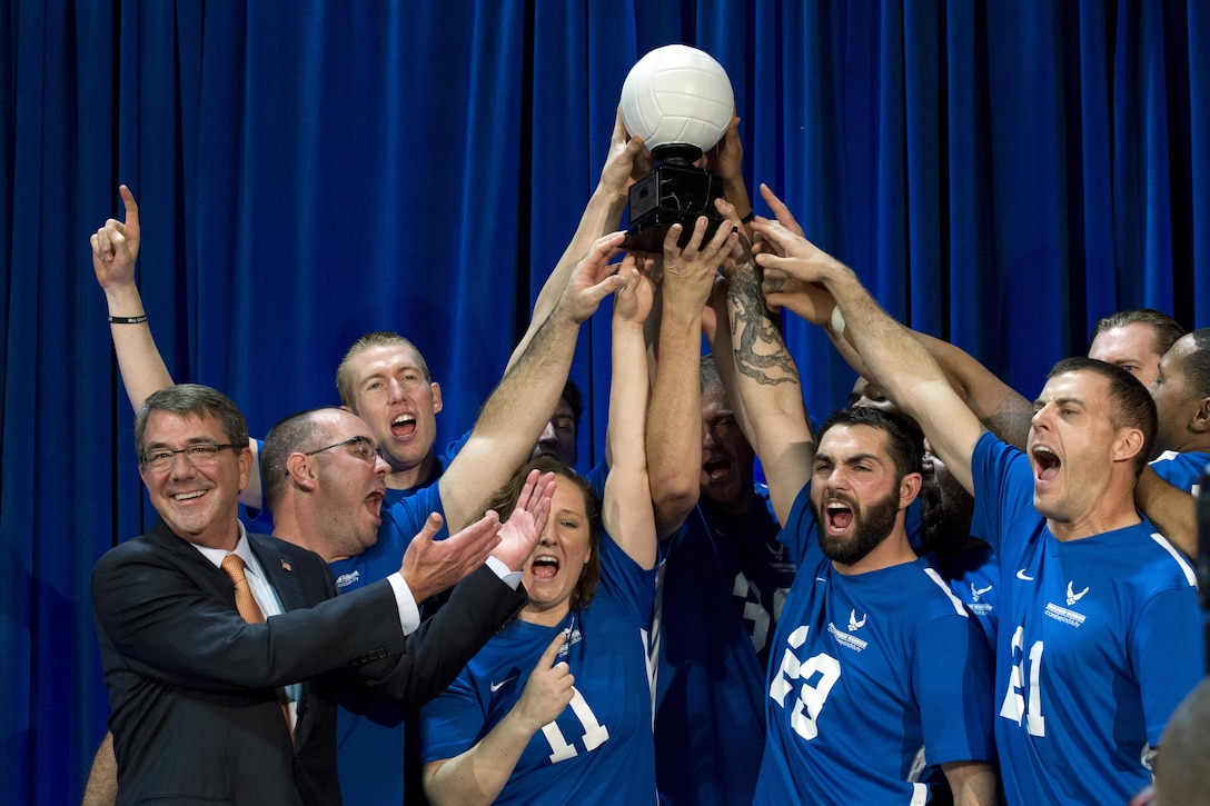 Defense Secretary Ash Carter awards a trophy to the Air Force sitting volleyball team for winning a joint service sitting volleyball tournament at the Pentagon, Nov. 19, 2015. DoD photo by EJ Hersom