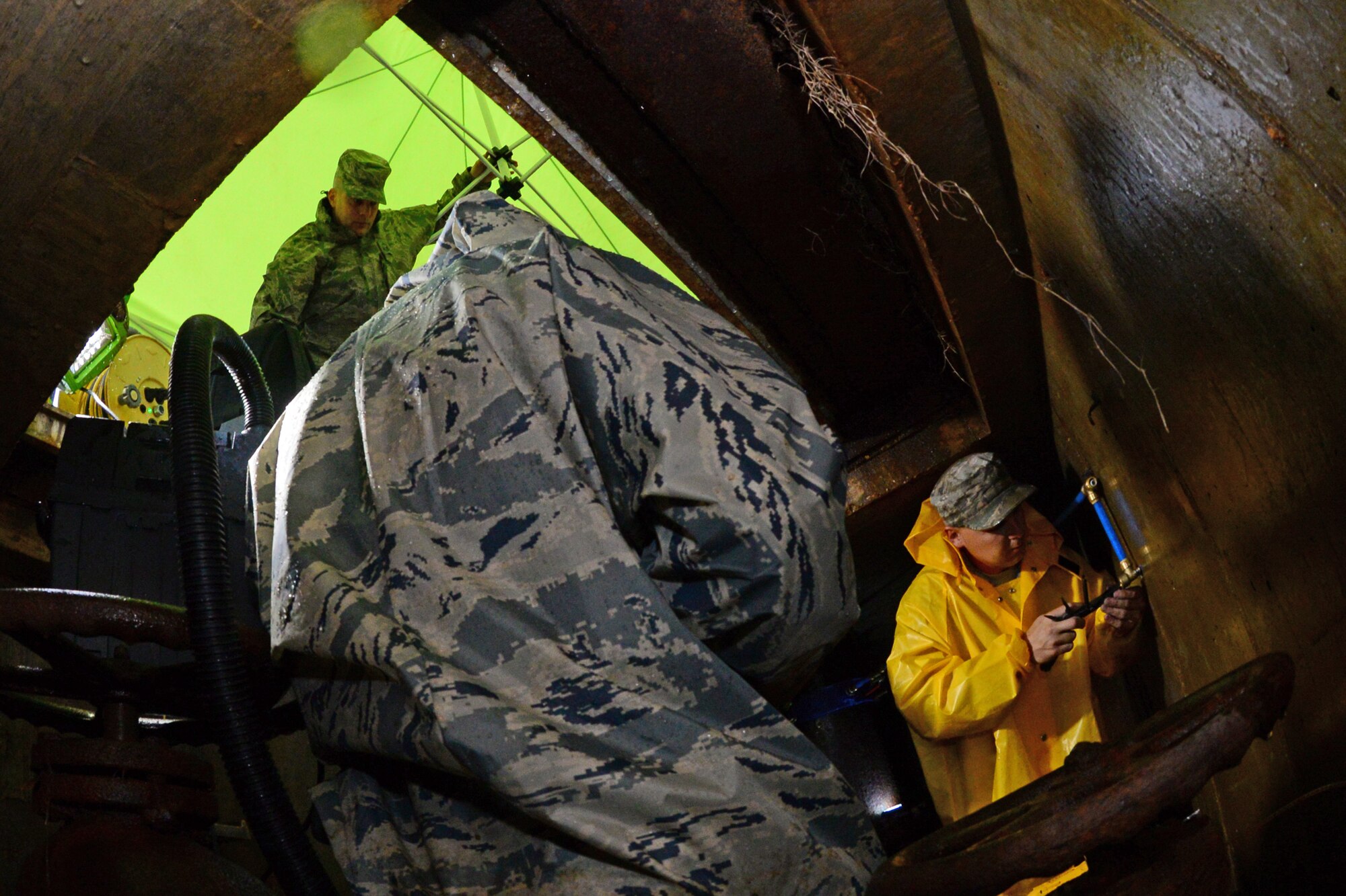 Staff Sgt. Thomas Zweydoff, 2nd Civil Engineer Squadron water and fuel systems craftsman, right, Airman 1st Class Chad Humann, 2nd CES water and fuel systems apprentice, and MSgt. Robert Westfall, 2nd CES water and fuel systems section chief, brave the elements while replacing a sensing line to the main gate water tower at Barksdale Air Force Base, La., Nov. 17, 2015.  Without a working sensing line the water line can overflow wasting water and creating flooding hazards. (U.S. Air Force Photo/Airman 1st Class Luke Hill)

