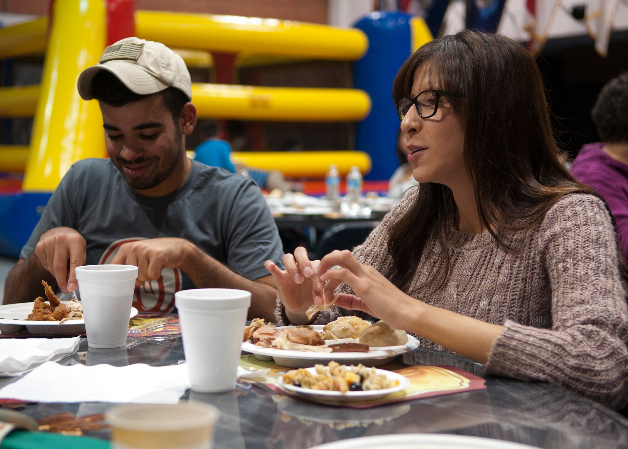 Second Lieutenants Octavio Otero and Jazmin Suarez, 90th Security Forces Squadron flight commanders, talk during the base chapel’s Thanksgiving dinner event in the Fall Hall Community Center Nov. 19, 2015. The chapel community, which consists of people from the traditional, Catholic and contemporary services, provided food for a Thanksgiving dinner served to chapel members and single Airmen. (U.S. Air Force photo by Airman 1st Class Malcolm Mayfield)