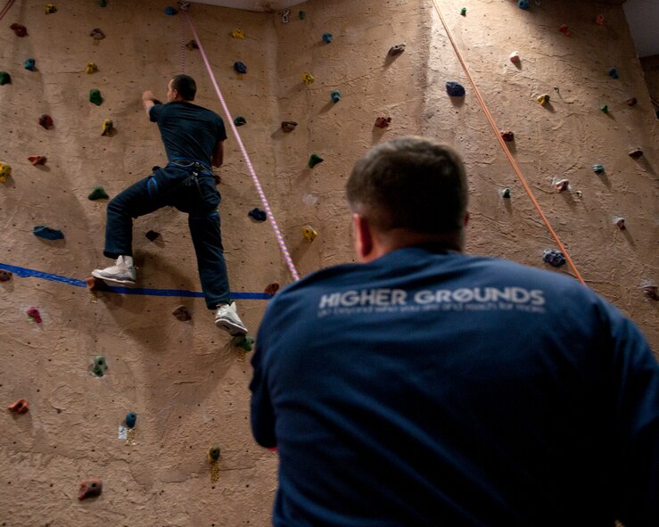 Airman 1st Class Timothy Cruz, 90th Comptrollers Squadron technician, climbs the indoor rock wall inside the Fall Hall Community Center Nov. 19, 2015, during the base chapel’s Thanksgiving dinner event.  Airmen and those from the chapel community were offered a variety of activities to connect, including rock climbing, laser tag and ping pong. (U.S. Air Force photo by Airman 1st Class Malcolm Mayfield)