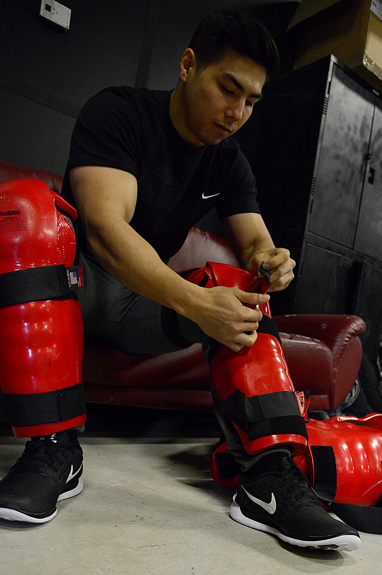 Airman 1st Class Kevin Kalgren, 51st Security Forces Security armory fastens on a “Redman” suit during the combat readiness course on Osan Air Base, Republic of Korea, Nov. 17, 2015. The Redman or red man suit is a full-body protective suit for instructors or volunteers to wear for protection during baton training. (U.S. Air Force photo/Senior Airman Kristin High)