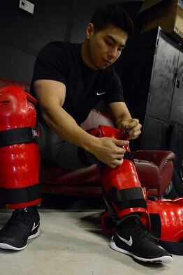 Airman 1st Class Kevin Kalgren, 51st Security Forces Security armory fastens on a “Redman” suit during the combat readiness course on Osan Air Base, Republic of Korea, Nov. 17, 2015. The Redman or red man suit is a full-body protective suit for instructors or volunteers to wear for protection during baton training. (U.S. Air Force photo/Senior Airman Kristin High)