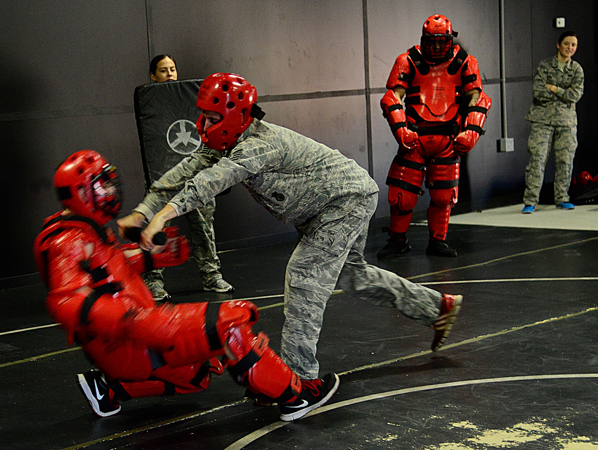 A 51st Security Forces Squadron defender pushes a “Redman” during the combat readiness course on Osan Air Base, Republic of Korea, Nov. 17, 2015. The Redman or red man suit is a full-body protective suit for instructors or volunteers to wear for protection during baton training. Redman training creates a realistic environment giving Airmen necessary hands-on experience to be able to take on someone who may be inebriated or overly aggressive. (U.S. Air Force photo/Senior Airman Kristin High)