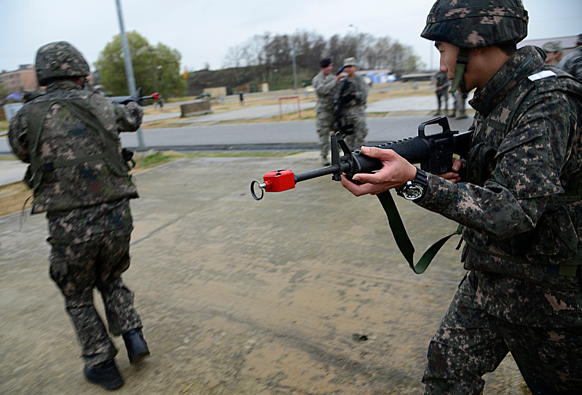 Republic of Korea airmen simulate entering a house during the combat readiness course on Osan Air Base, ROK, Nov. 17, 2015. The ROKAF airmen attended the training to learn better and more effective ways of communication and training along with teaching some skills the defenders may not use. “We have the same mission here as the U.S. defenders -- protect the base,” said 1st Lt. James Park, ROKAF 3rd Training Wing special duty team. (U.S. Air Force photo/Senior Airman Kristin High)