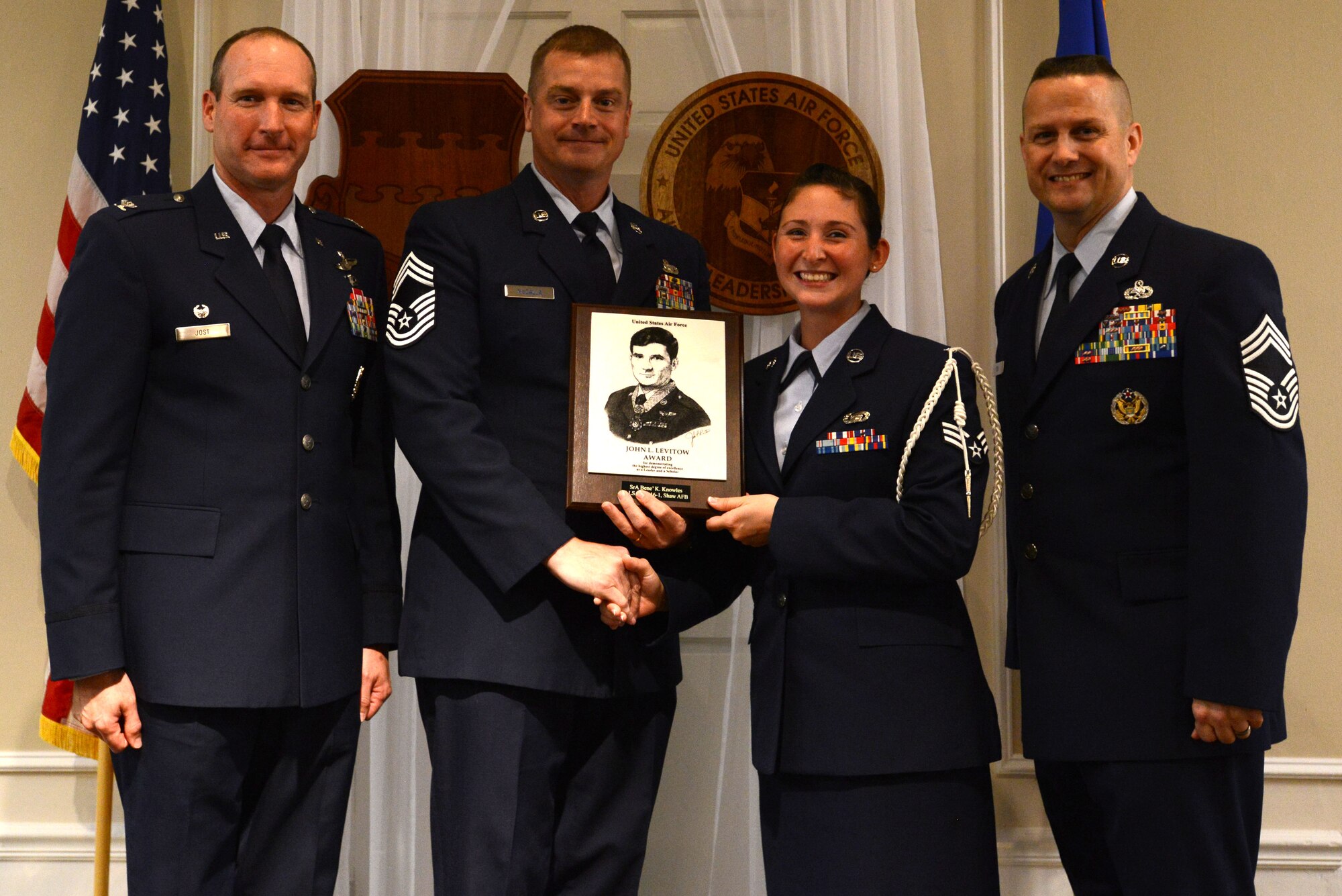 U.S. Air Force Senior Airman Bene Knowles, 31st Intelligence Squadron, receives the John L. Levitow Award for the Senior Master Sgt. David B. Reid Airman Leadership School Class 16-1, from Chief Master Sgt. Scott McCalla, 20th Mission Support Group superintendent, at Shaw Air Force Base, S.C., Nov. 20, 2015. The Levitow Award is given to the graduate with the highest average of instructor and student points, and is the highest award in enlisted professional military education. (U.S. Air Force photo by Airman 1st Class Kelsey Tucker)