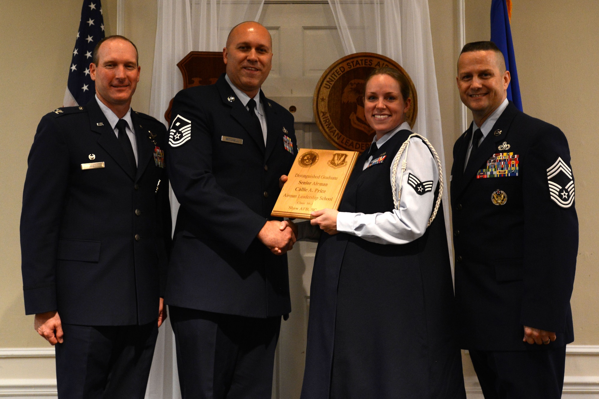 U.S. Air Force Senior Airman Callie Price, 31st Intelligence Squadron, receives a distinguished graduate award for the Senior Master Sgt. David B. Reid Airman Leadership School Class 16-1 from Master Sgt. Jeremy Mitchell, 20th Equipment Maintenance Squadron first sergeant, at Shaw Air Force Base, S.C., Nov. 20, 2015. The distinguished graduate awards are given to the top 10 percent of the class for total point accumulation. (U.S. Air Force photo by Airman 1st Class Kelsey Tucker)