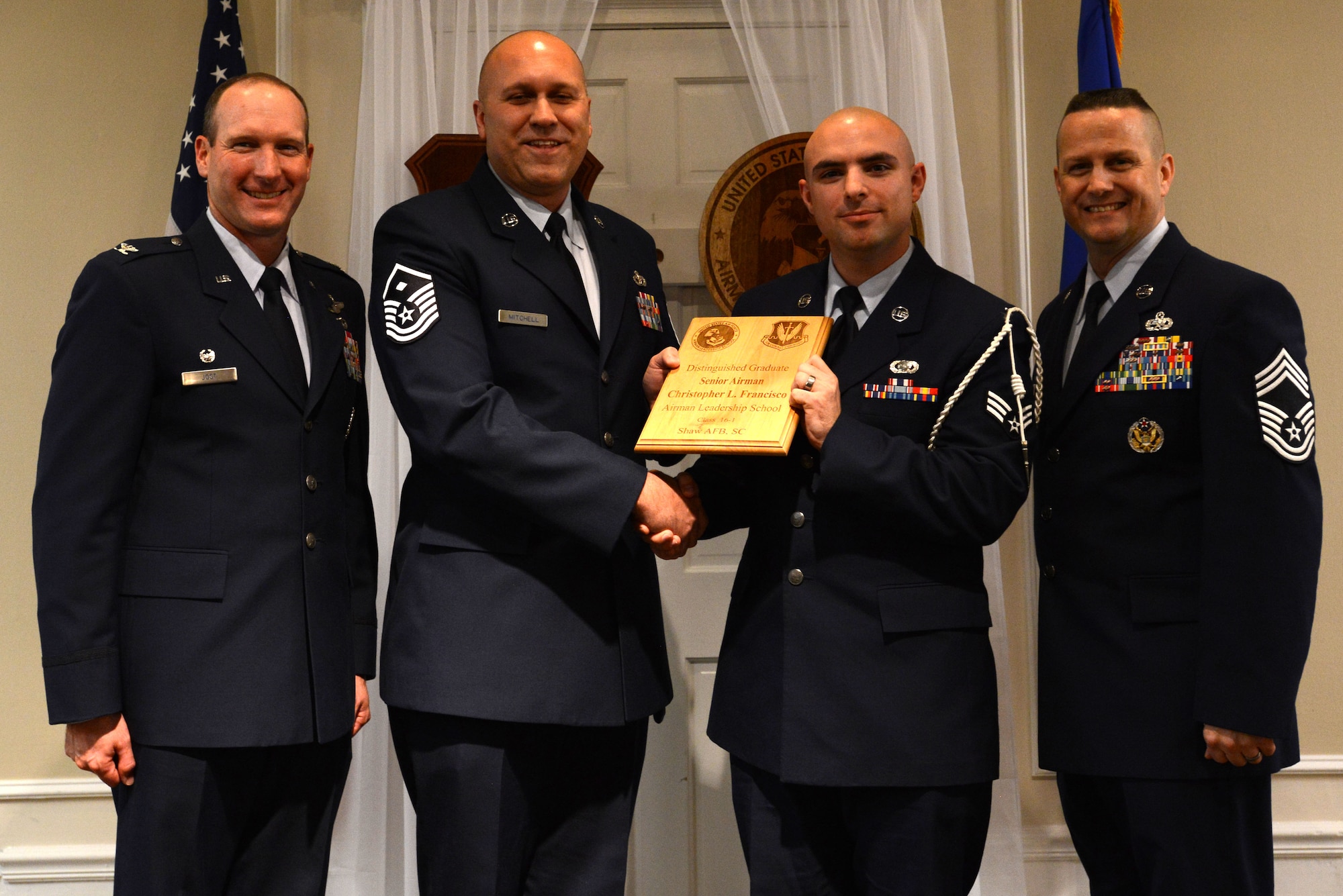 U.S. Air Force Senior Airman Christopher Francisco, 31st Intelligence Squadron, receives a distinguished graduate award for the Senior Master Sgt. David B. Reid Airman Leadership School Class 16-1 from Master Sgt. Jeremy Mitchell, 20th Equipment Maintenance Squadron first sergeant, at Shaw Air Force Base, S.C., Nov. 20, 2015. The distinguished graduate awards are given to the top 10 percent of the class for total point accumulation. (U.S. Air Force photo by Airman 1st Class Kelsey Tucker)