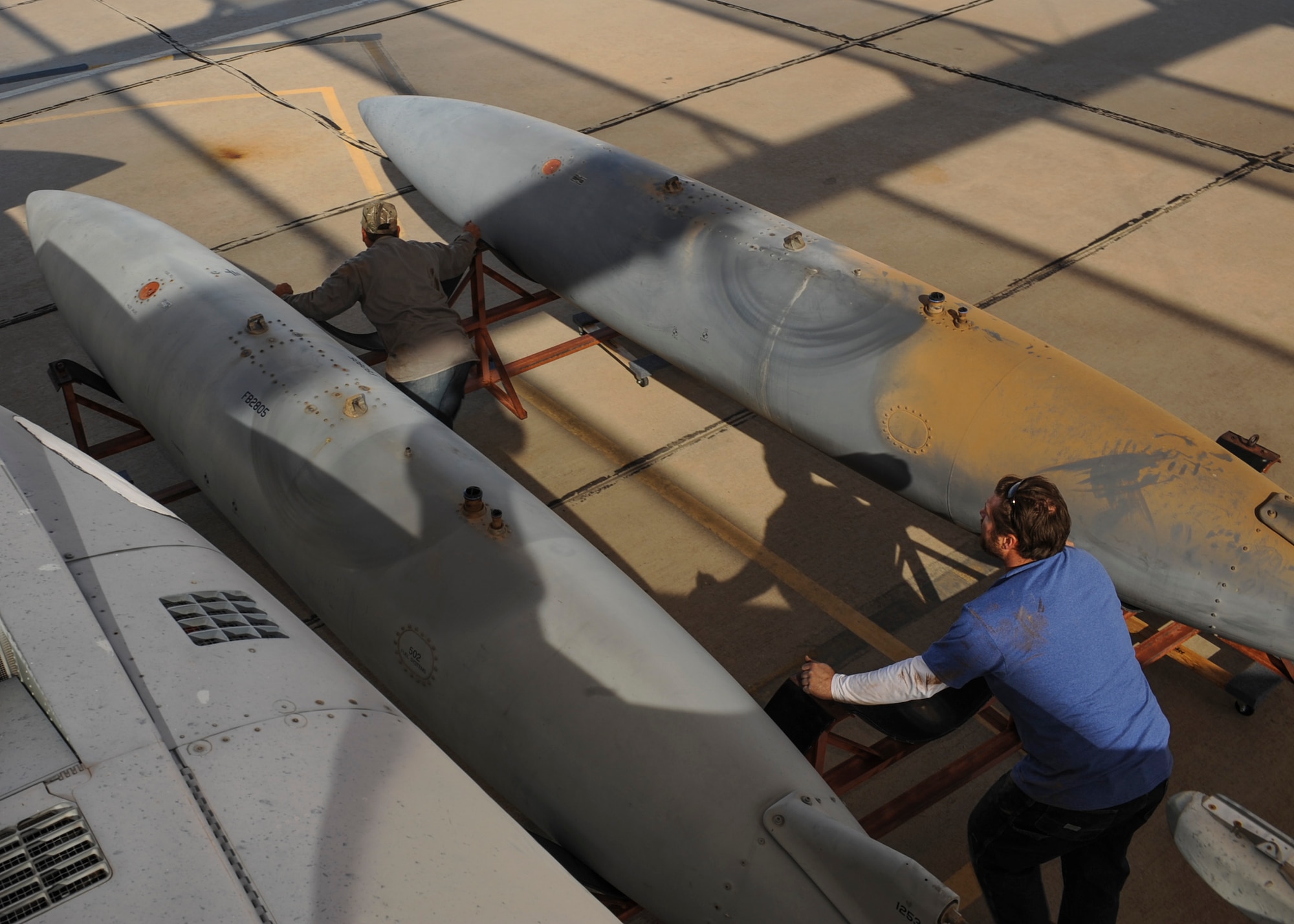 David Williamson, chief project manager, and Tony Martinez, crane mechanic, move a fuel tank from an F-15A Eagle on the flight line at Davis-Monthan Air Force Base, Ariz., Nov. 17, 2015. A team of contractors took five days to completely disassemble the F-15A Eagle and load it onto two flatbed trucks to be shipped to Joint Base Lewis-McChord, Wash., for display. The entire project is estimated to take approximately eight months from the planning stage to finish. (U.S. Air Force photo by Airman Basic Nathan H. Barbour/Released)