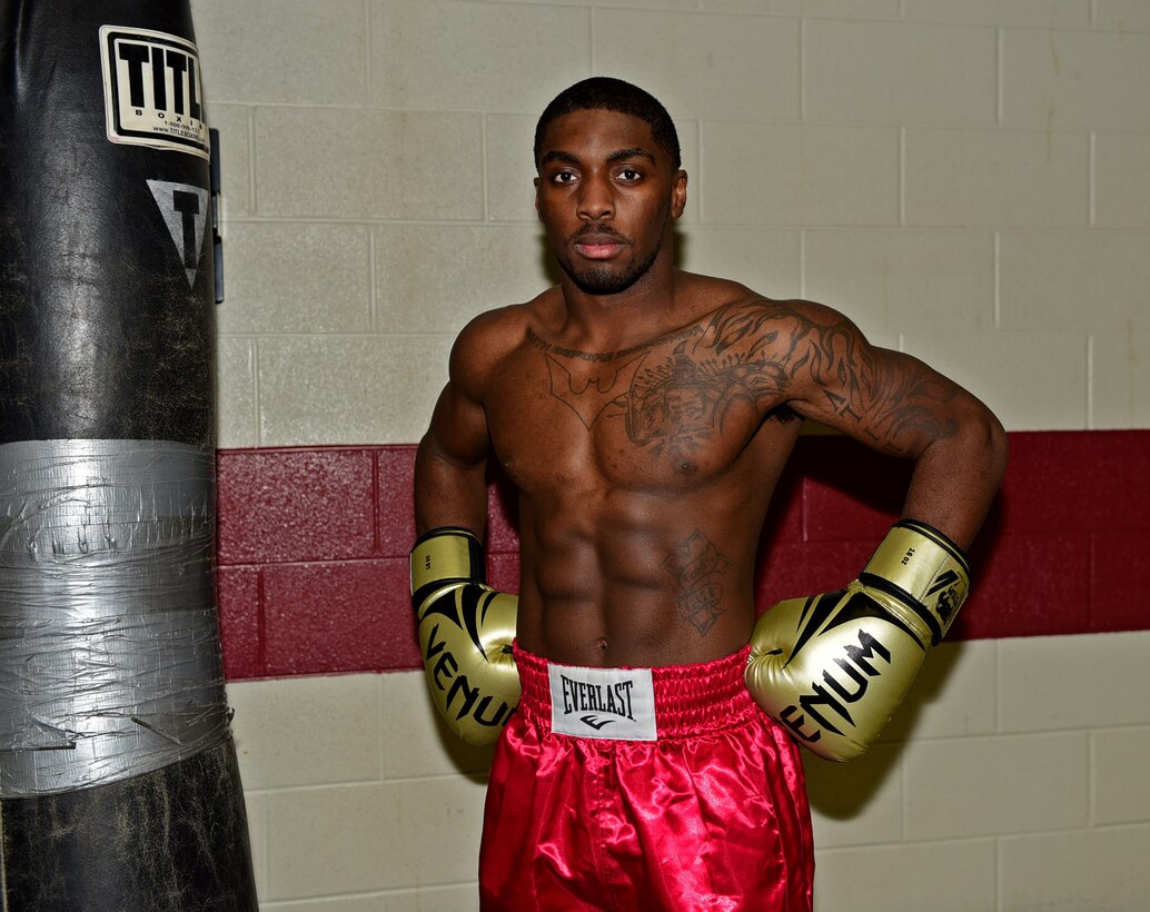 Senior Airman Colton Taylor, 28th Force Support Squadron services journeyman, poses with his boxing gear at Ellsworth Air Force Base, S.D., Nov. 10, 2015. Taylor started boxing to stay in shape, but now fights to help raise money and sends half of his earnings to his family to aid his grandfather who is battling liver cancer. (U.S. Air Force photo by Airman 1st Class James L. Miller/Released)