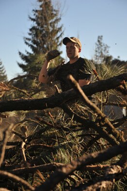 Senior Airman Matthew Montour, 336th Training Group Survival Evasion Resistance and Escape specialist, breaks down branches during a volunteer community cleanup event, Nov. 20, 2015 in Spokane, Wash. Members from the 336th TRG helped clear downed trees after a severe windstorm that caused damage to the area. (U.S. Air Force photo/Staff Sgt. Jason Bailey) 