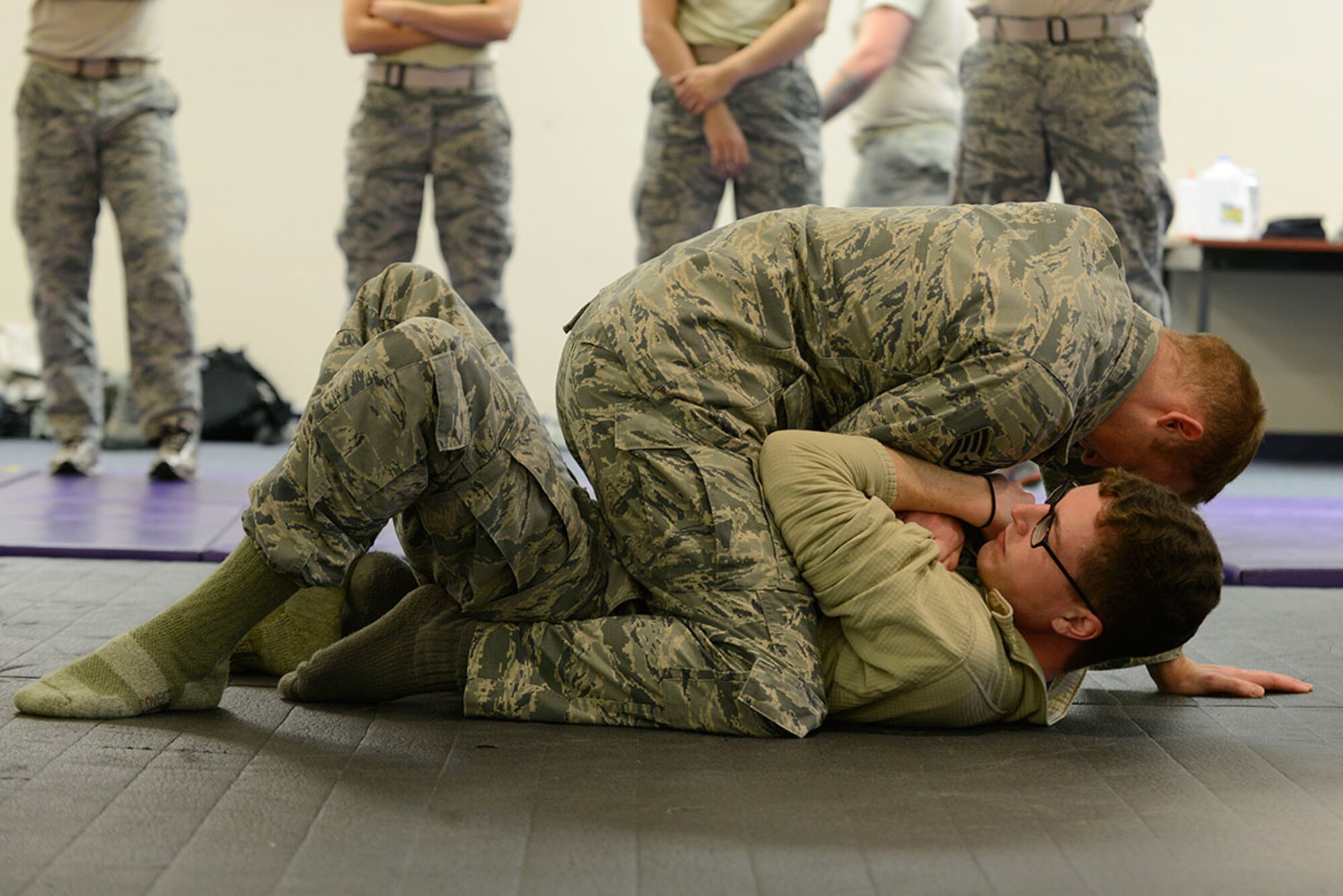 Staff Sergeants Adrian Durr, bottom, and Joshua Heffley, top, demonstrate one of the 29 combatives techniques during combatives training at Joint Base Elmendorf-Richardson, Alaska, Nov. 9, 2015. Combatives training is designed to equip defenders with the knowledge and skills to respond to potentially deadly confrontations. Durr and Heffley are both combatives instructors assigned to the 673d Security Forces Squadron. (U.S. Air Force photo by Airman Valerie Monroy)