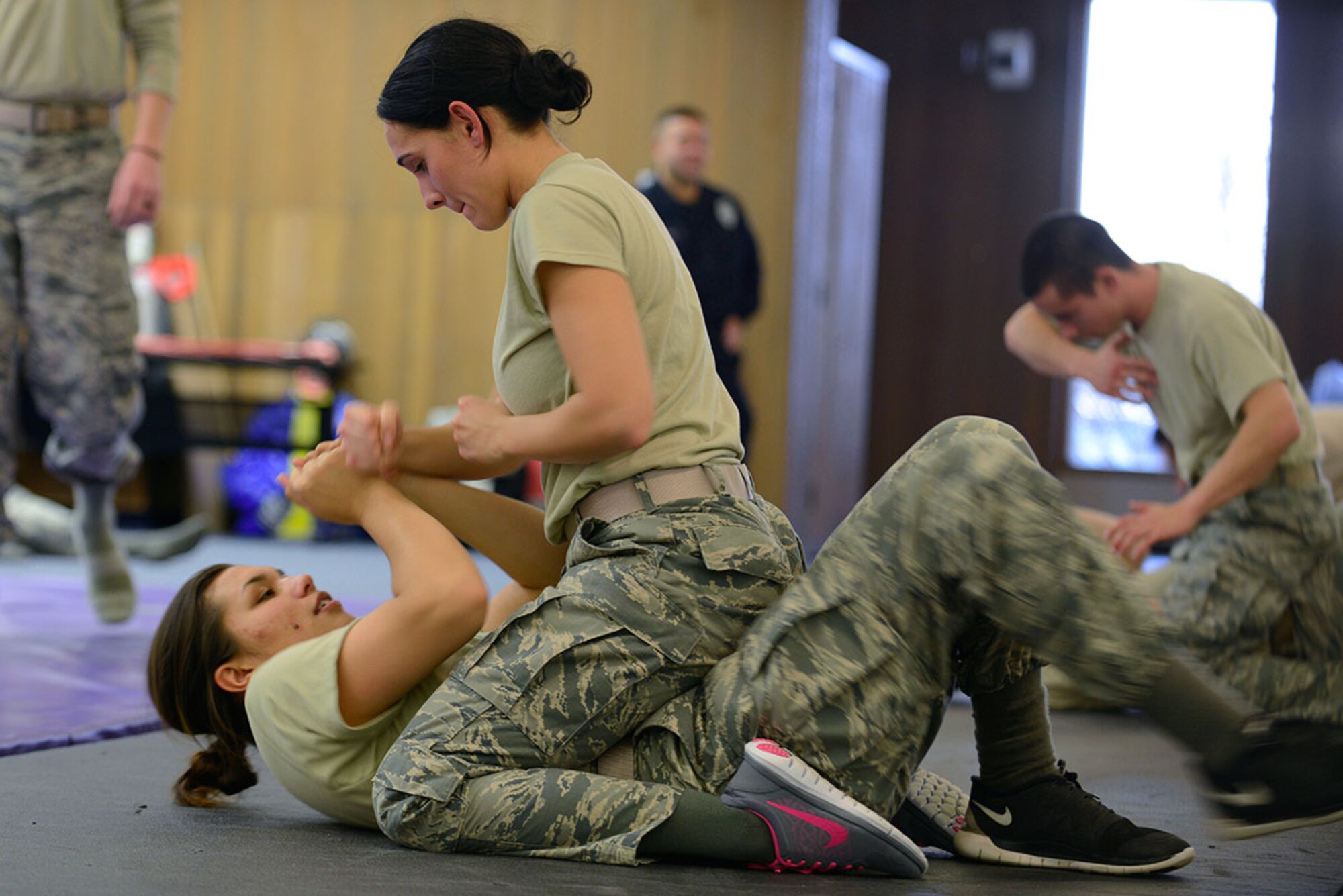 Airman 1st Class Melanie Bautista-Manning demonstrates the proper dominant mount on Airman 1st Class Olivia Jaymes during combatives training at Joint Base Elmendorf-Richardson, Alaska, Nov. 9, 2015. Combatives training gives defenders the opportunity to test their capabilities, reaction time and endurance in a controlled environment. Bautista-Manning and Jaymes are both assigned to the 673d Security Forces Squadron. (U.S. Air Force photo by Airman Valerie Monroy)