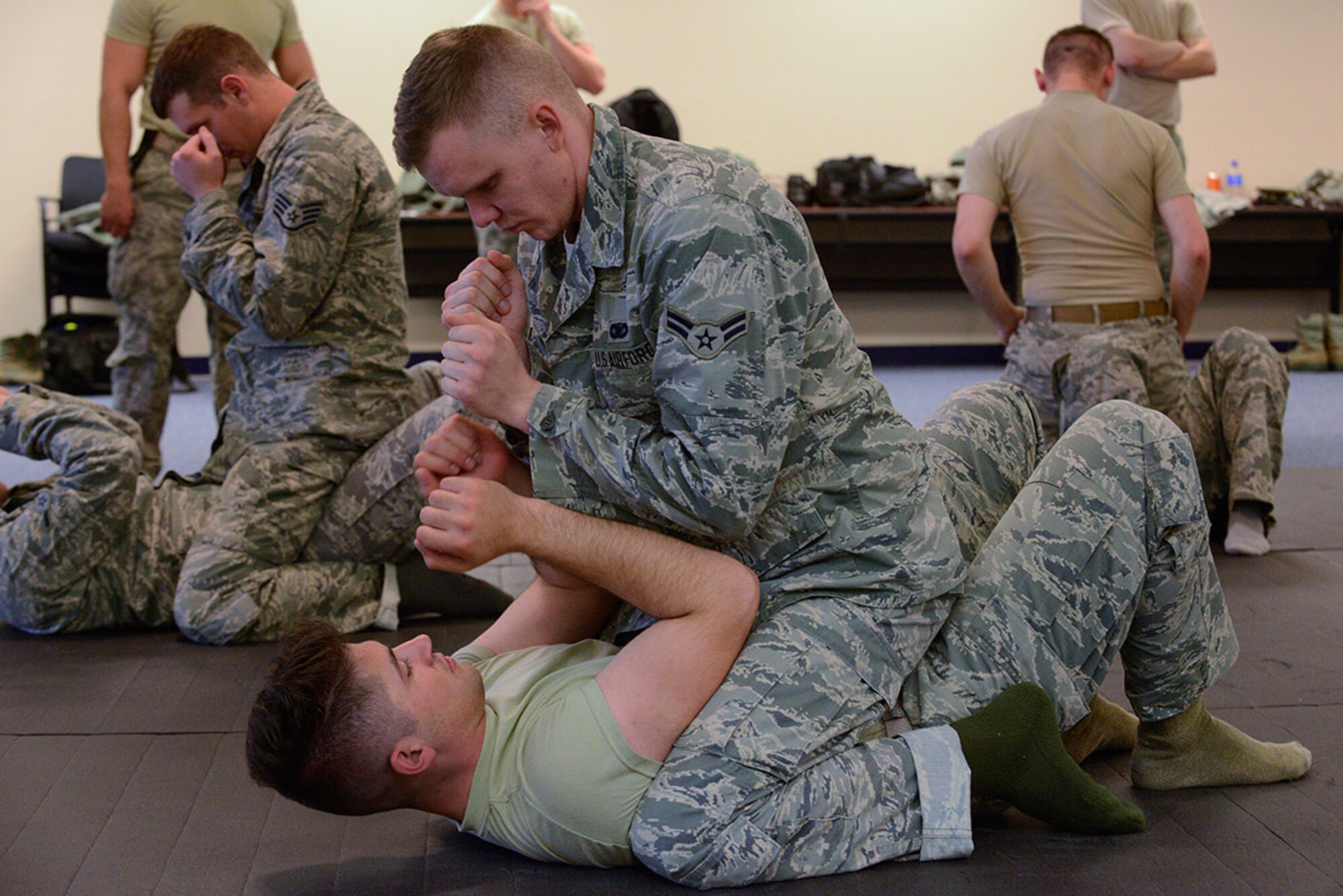 Airman 1st Class Thomas Bastien demonstrates the proper dominant mount on Airman 1st Class Christian Thomas during combatives training at Joint Base Elmendorf-Richardson, Alaska, Nov. 9, 2015. The combatives training was aimed at improving the skills of security forces defenders. Bastien and Thomas are both assigned to the 673d Security Forces Squadron. (U.S. Air Force photo by Airman Valerie Monroy)