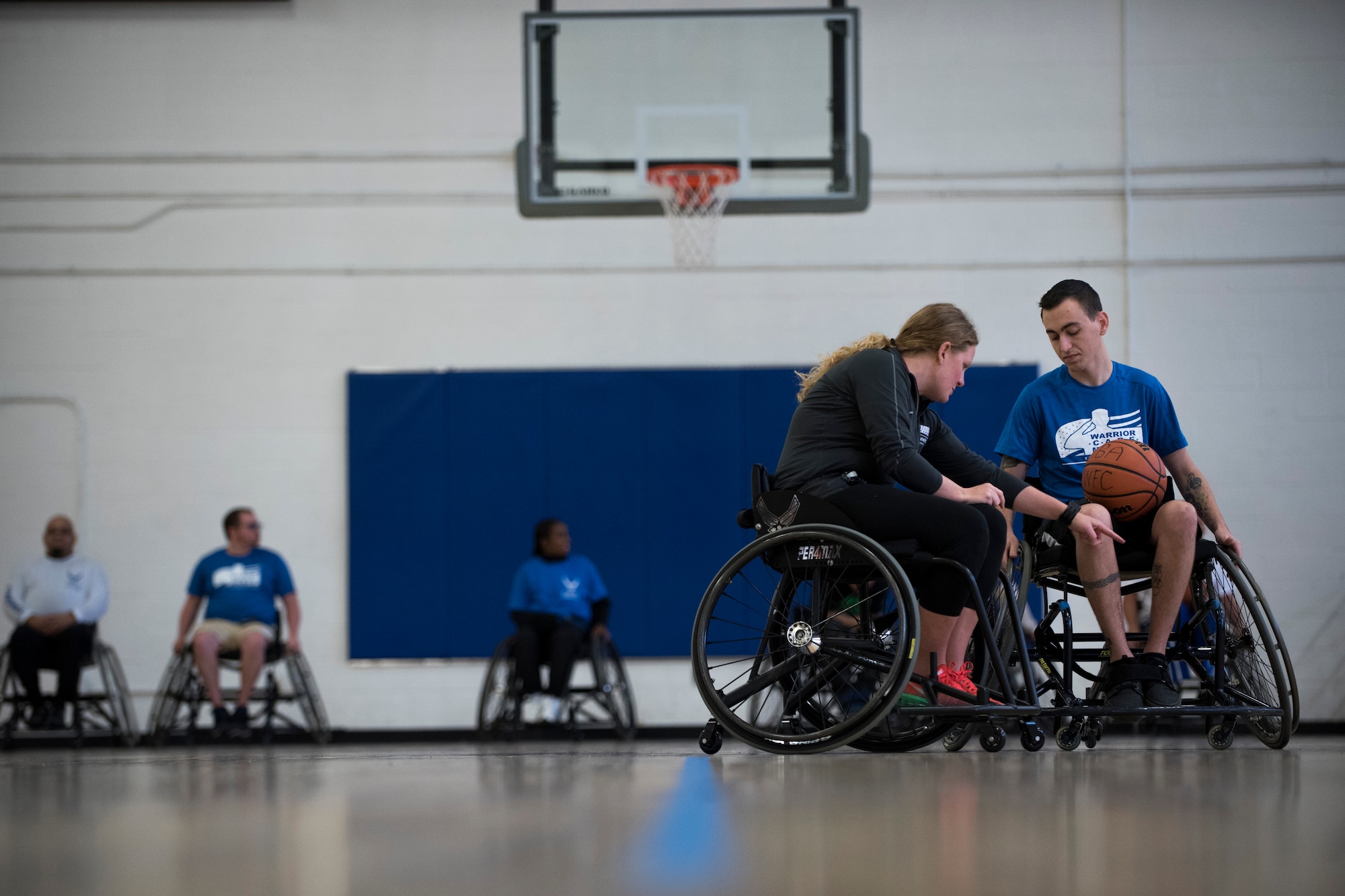 Senior Airman Austen Strait, right, is coached on wheelchair basketball techniques during the Northeast Region Warrior CARE Event at Joint Base Andrews, Md., Nov. 18, 2015. November is Warrior Care Month and dedicated to honoring wounded, ill and injured service members, their families and their caregivers. (U.S. Air Force photo/Airman 1st Class Philip Bryant)