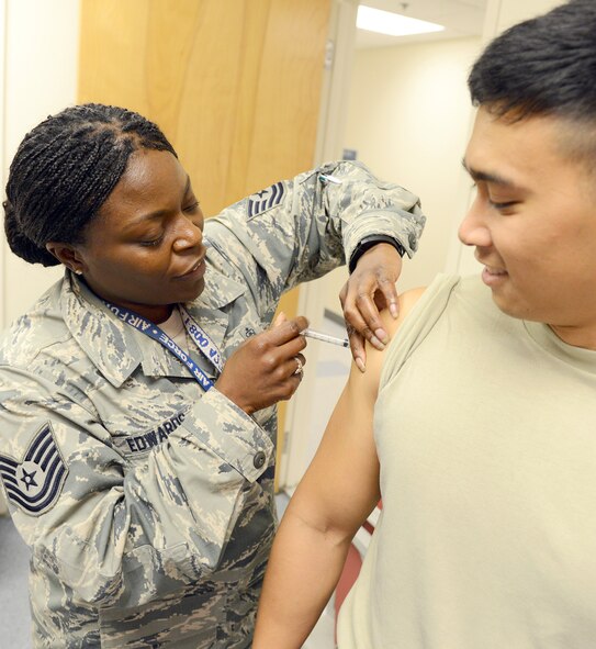 Technical Sgt. Konshinea Edwards, 78th Medical Group maternal child flight chief, immunizes Staff Sgt. Tam Nguyen, 78th MDG, at the base medical clinic. (U.S. Air Force photo by Tommie Horton)