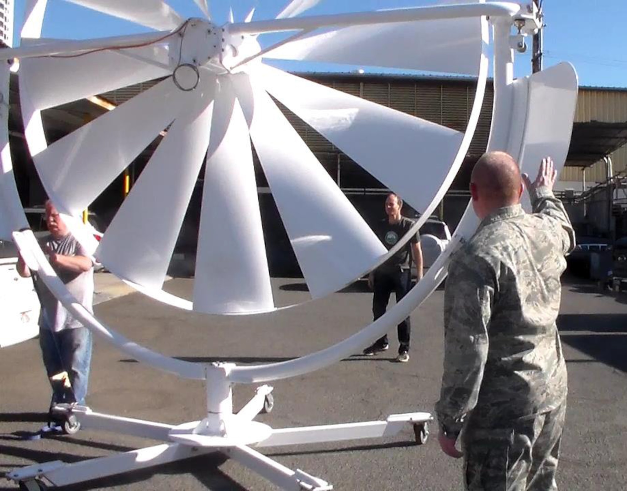 Natural Power Concepts personnel and Lt Col Scott Fitzner of the AFRL Materials and Manufacturing Directorate inspect the Spoke Wheel Medium Wind Power System, one of a number of energy-harvesting technologies being installed as part of the five-year, $20M cooperative agreement with AFRL that will establish a microgrid demonstration project at Joint Base Pearl Harbor-Hickam in Hawaii.  (Photo courtesy of Hawaii Center for Advanced Transportation Technologies)