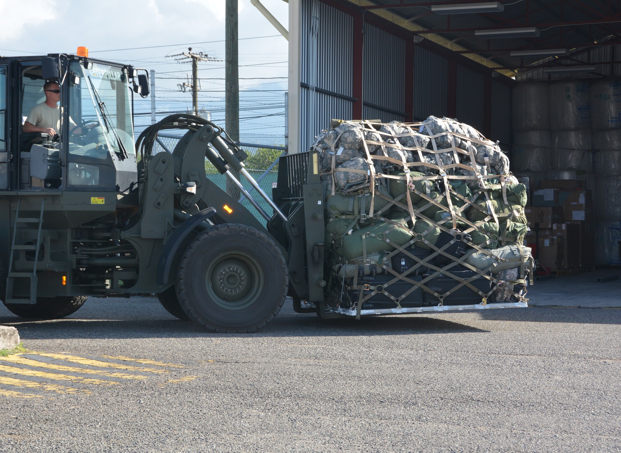 A 612th Air Base Squadron member loads Joint Security Forces members' cargo as they redeploy from Soto Cano Air Base, Honduras, Nov. 19, 2015, after completing their deployment in Honduras. The JSF members returned to Puerto Rico after they were stationed in Honduras for nine months. (U.S. Air Force photo by Martin Chahin/Released)