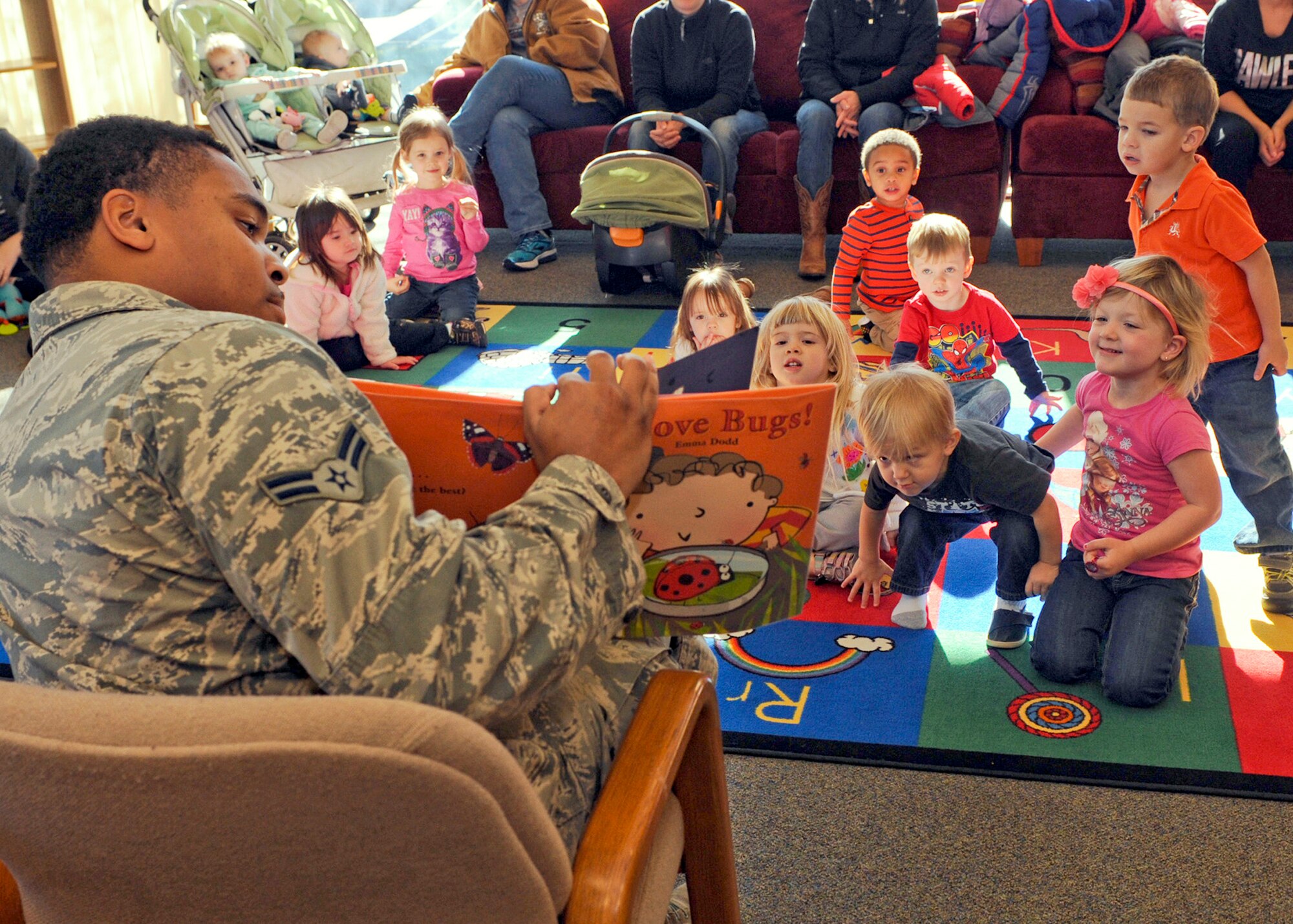 Airman 1st Class Terrell Jackson, 28th Logistics Readiness Squadron pest management journeyman, reads to children during the Holbrook Library’s Little Warriors Story Time program at Ellsworth Air Force Base, S.D., Nov. 12, 2015. The program aims to promote literacy in children of all ages. (U.S. Air Force photo by Airmen Sadie Colbert/Released)