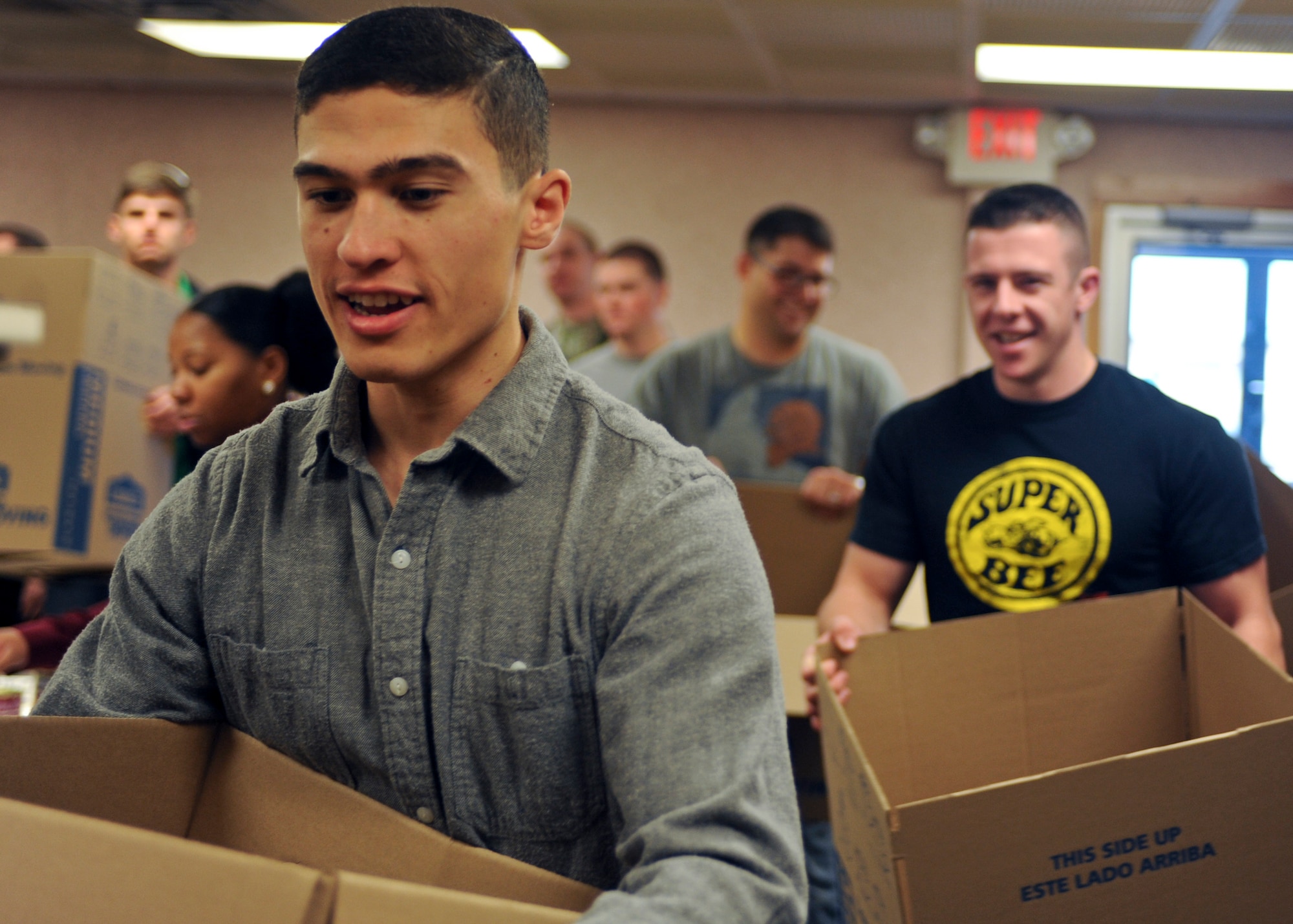 Senior Airman Charles Lockamy, 28th Operations Support Squadron weather forecaster, helps assemble an Operation Warmheart food package at Ellsworth Air Force Base, S.D., Nov. 14, 2015. The annual program provides select Airmen with an assortment of holiday food items. (U.S. Air Force photo by Airman Sadie Colbert/Released)