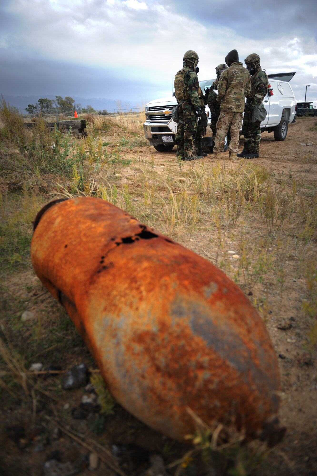 Airmen gather on the 775th Explosive Ordnance Disposal Flight training range, to discuss their plans and procedures before processing a scene containing chemical weapons. The training scenario was part of a week-long training event Nov. 2.-6, meant to pass on knowledge from veteran EOD techs to their younger counterparts. (U.S. Air Force photo/Micah Garbarino)