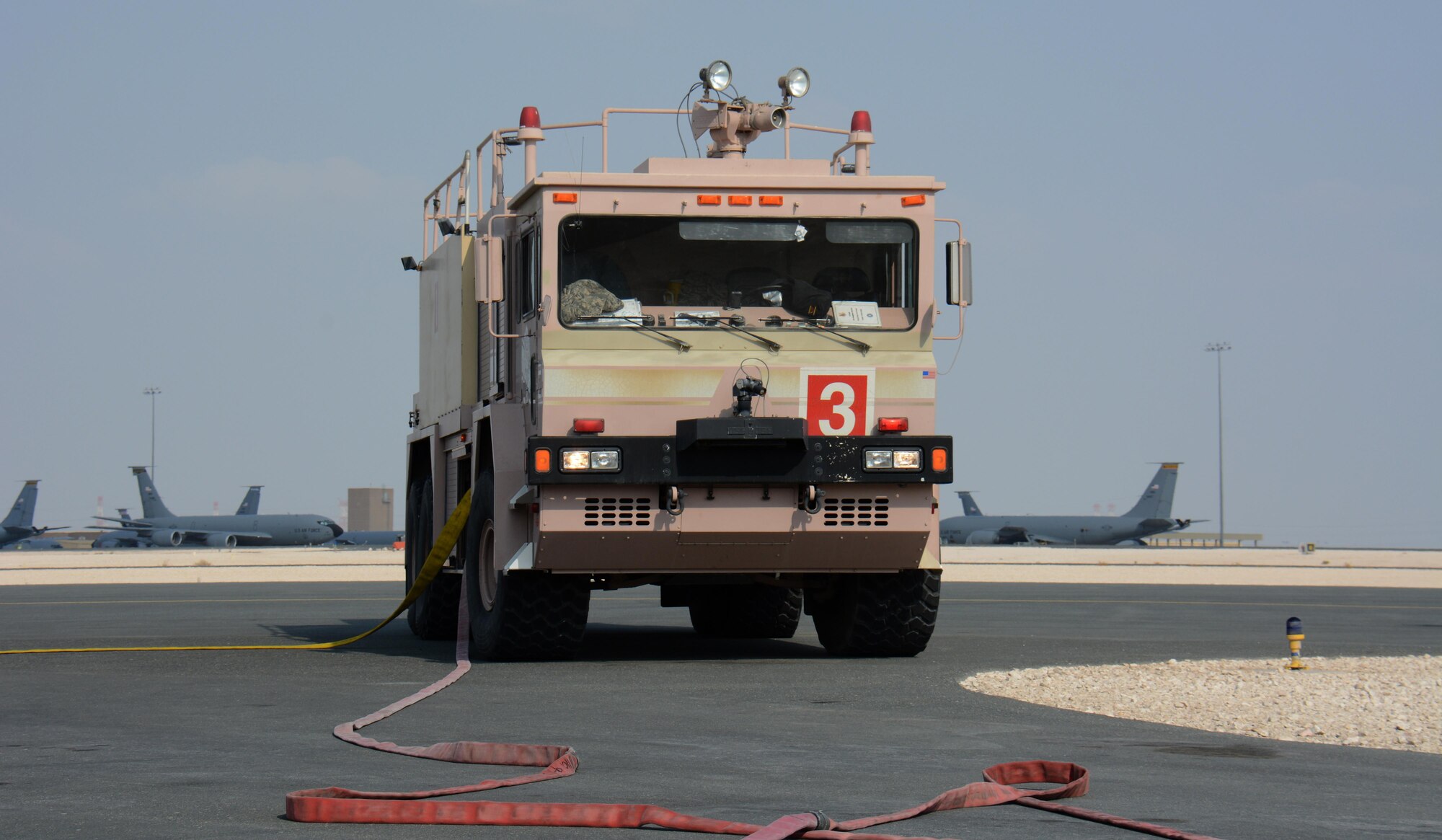 A 379th Civil Engineer Squadron firetruck is parked near the flight line at Al Udeid Air Base, Qatar Nov. 20 during a response to a training exercise. The exercise featured a simulated fire on a KC-135 Stratotanker and required firefighters to rescue an injured air crew member. Within minutes, several firefighters climbed on to the plane's left wing, entered the aircraft and pulled the injured air crew member to safety. Training exercises help first responders maintain their skillsets. (U.S. Air Force photo by Tech. Sgt. James Hodgman/Released)