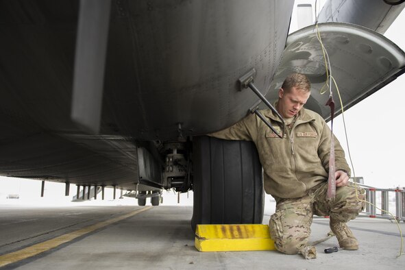 Staff Sgt Mitchell Miller, 41st Expeditionary Aircraft Maintenance Unit EC-130 crew chief, deployed from Davis-Monthan Air Force Base, Ariz., assists in replacing a mud guard panel on an EC-130H Compass Call after repairing a refuel manifold Nov. 19, 2015, at Bagram Airfield, Afghanistan. The Compass Call is an airborne tactical weapon system using a heavily modified version of the C-130 Hercules airframe. (U.S. Air Force photo by Tech. Sgt. Robert Cloys/Released)