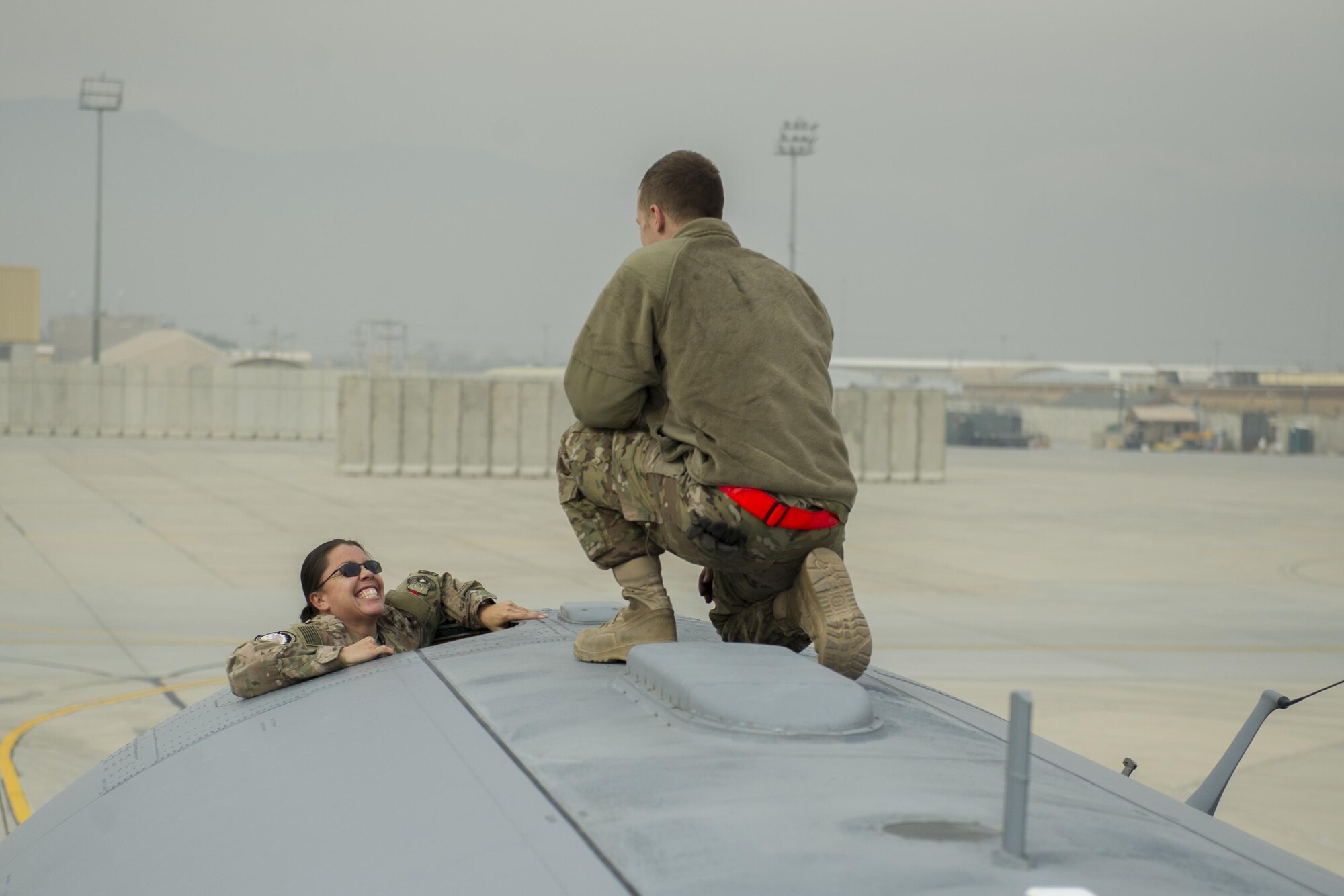 Master Sgt. Christina Trombley, 455 Expeditionary Aircraft Maintenance Squadron first sergeant, climbs on top of a EC-130H Compass Call aircraft during a visit with Airmen from the 41st Expeditionary Aircraft Maintenance Unit deployed from Davis-Monthan Air Force Base, Ariz., Nov. 19, at Bagram Airfield, Afghanistan. The Compass Call is an airborne tactical weapon system using a heavily modified version of the C-130 Hercules airframe. (U.S. Air Force photo by Tech. Sgt. Robert Cloys/Released)
