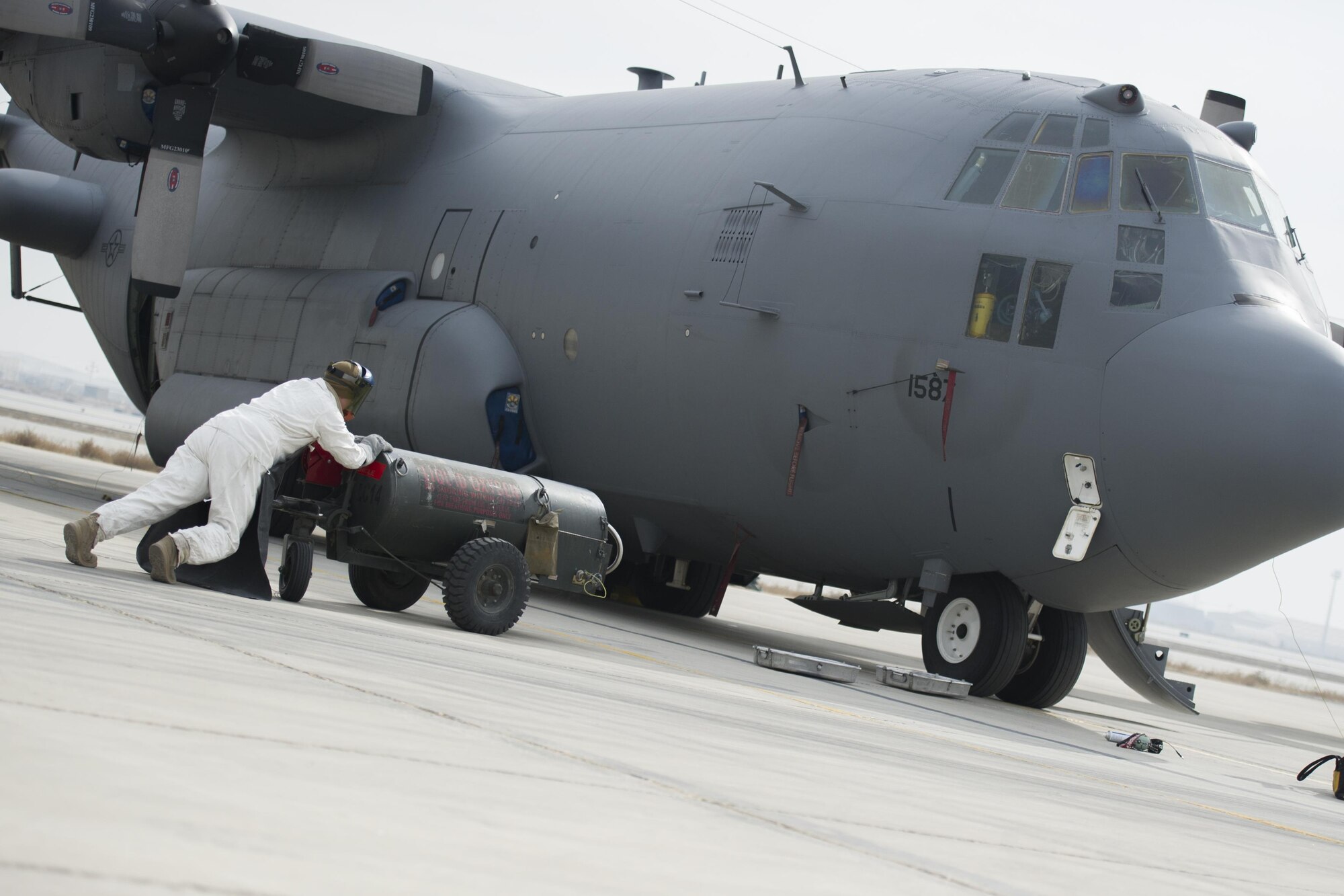 Senior Airman Clark Hoover-Hill, 455th Expeditionary Aircraft Maintenance Squadron electrical and environmental systems journeyman, deployed from Davis-Monthan Air Force Base, Ariz., pushes a tank of liquid oxygen to an EC-130 aircraft at Bagram Airfield, Afghanistan, Nov. 19, 2015. The 455th EAMXS is responsible for preparing military aircraft on Bagram for flight and returning them to a mission-ready state once they land. (U.S. Air Force photo by Tech. Sgt. Robert Cloys/RELEASED)
