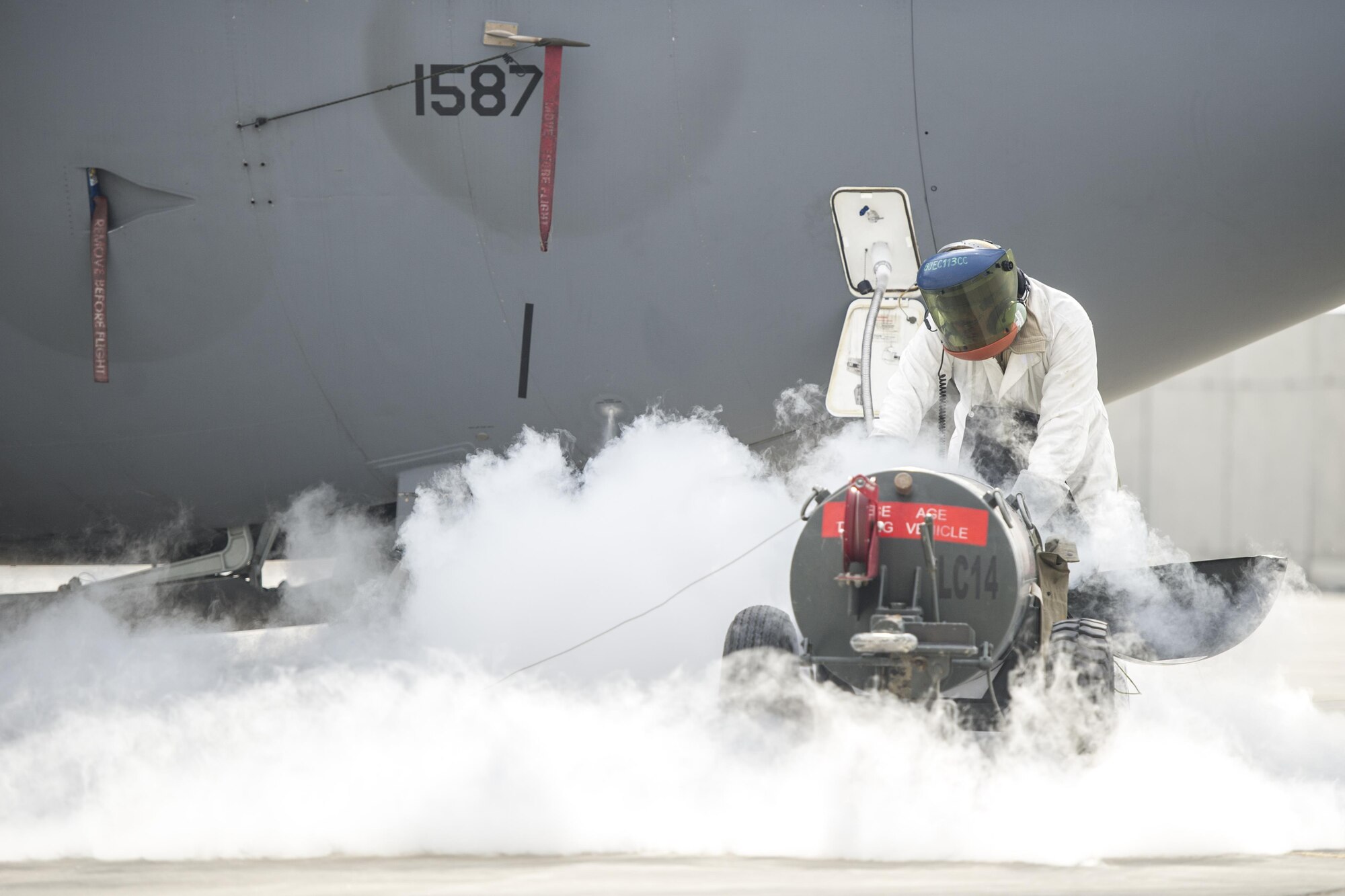 Senior Airman Clark Hoover-Hill, 455th Expeditionary Aircraft Maintenance Squadron electrical and environmental systems journeyman, deployed from Davis-Monthan Air Force Base, Ariz., services the liquid oxygen on an EC-130 aircraft at Bagram Airfield, Afghanistan, Nov. 19, 2015. When exposed to the open air, the minus 297 degree LOX evaporates into a gas.. (U.S. Air Force photo by Tech. Sgt. Robert Cloys/RELEASED)