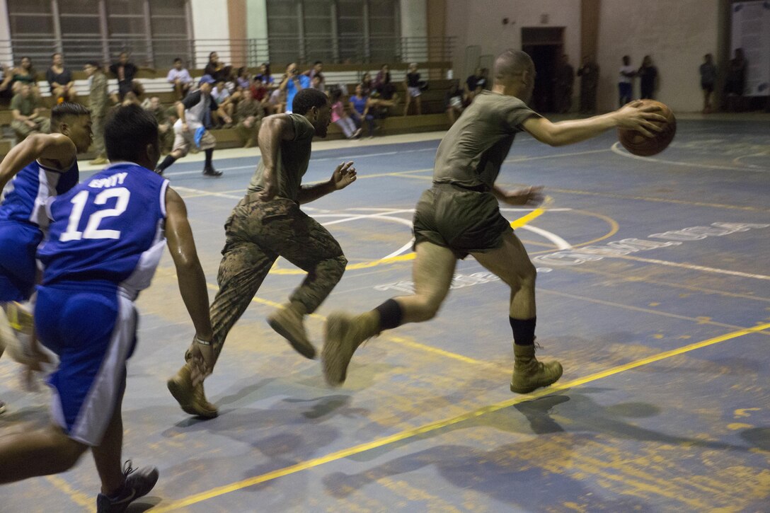 Marines from Company A, B, and C, 1st Battalion, 2d Marine Regiment, took part in a basketball game against the Tinian High School team. The Marines took part in community relations efforts with the people of Tinian, Commonwealth of the Northern Mariana Islands, on Nov. 17, 2015, after being deployed on short notice from Fuji to notionally secure the expeditionary airfield and conduct training. The training allowed the Marines an opportunity to establish long-range communications and receive professional military education in order to ensure utilization and validation of the Marianas Islands Range Complex, improve the Marines' understanding and appreciation for unit history, and validate elements of the Alert Contingency MAGTF.