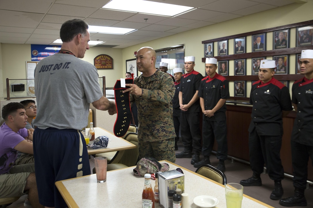 Marines present Jamie Dixon, the head coach of University of Pittsburgh Men’s Basketball Team, with a stocking Nov. 12 on Marine Corps Air Station Futenma, Okinawa, Japan. The stocking was pinned with the different ranks of the Marines working at the mess hall.   Pittsburgh faced off against Gonzaga University in the ESPN Armed Forces Classic Basketball Game held on Okinawa. This marked the fourth year the Armed Forces Classic was held and the second time it was played in East Asia.