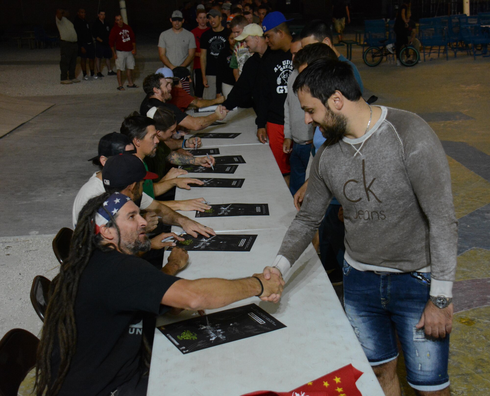 Deployed service members at Al Udeid Air Base, Qatar meet members of Bikes Over Baghdad after the group performed at the base Nov. 22. The group thanked every service member who attended the show for their service. Bikes Over Baghdad is a professional BMX bike group that tours the world performing for service members. (U.S. Air Force photo by Tech. Sgt. James Hodgman/Released)