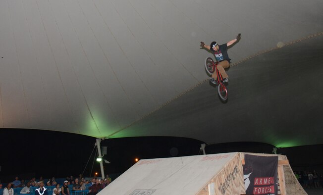 A member of Bikes Over Baghdad executes a jump with no hands on the handle-bars during a performance at Al Udeid Air Base, Qatar Nov. 22. Bikes Over Baghdad is a professional BMX bike group that tours the world performing for service members. After their show they also met with service members and signed autographs. (U.S. Air Force photo by Tech. Sgt. James Hodgman/Released)