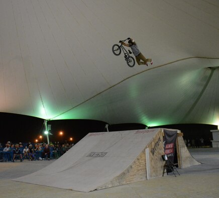 A member of Bikes Over Baghdad executes a jump with no hands on the handle bars during a performance at Al Udeid Air Base, Qatar Nov. 22. Bikes Over Baghdad is a professional BMX bike group that tours the world performing for service members. After their show they also met with service members and signed autographs. (U.S. Air Force photo by Tech. Sgt. James Hodgman/Released)