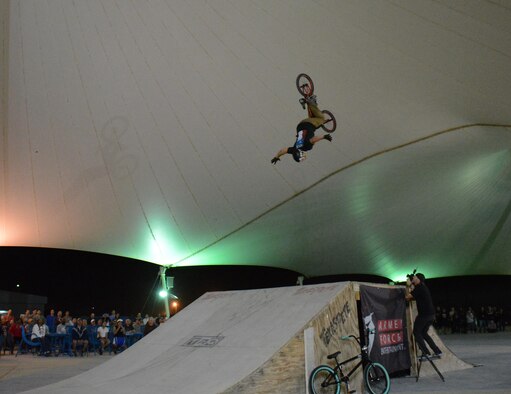 A member of Bikes Over Baghdad executes a jump with no hands on the handle bars during a performance at Al Udeid Air Base, Qatar Nov. 22. Bikes Over Baghdad is a professional BMX bike group that tours the world performing for service members. After their show they also met with service members and signed autographs. (U.S. Air Force photo by Tech. Sgt. James Hodgman/Released)