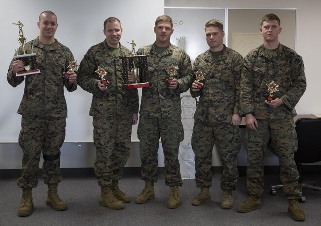 Marines of Headquarters and Headquarters Squadron pose for a picture after being awarded first place for the intramural pistol matches at Marine Corps Air Station Iwakuni, Japan, Nov. 19, 2015. Intramural pistol matches are designed to introduce participants to the competition in arms program style of shooting, enabling Marines to compete in a match locally run. This allows more participation and helps identify Marines that may do well at the Far East Division Matches in Okinawa.