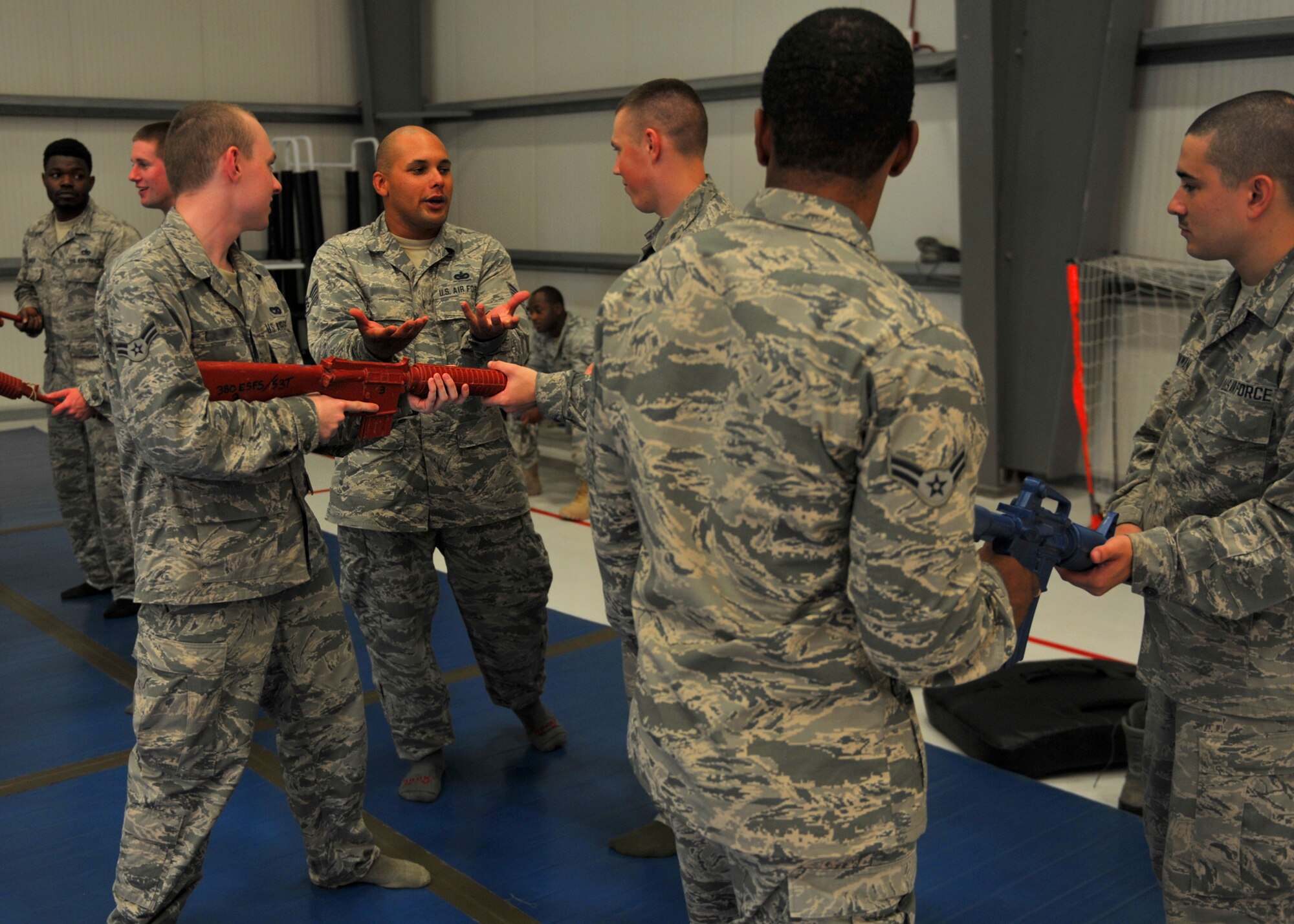 Staff Sgt. James, combatives course instructor with the 380th Expeditionary Security Forces Squadron, explains how to react to a potential opponent grabbing a weapon during the weapons control portion of combative training here, Oct. 15, 2015.  Techniques included learning basic unarmed strikes, weapon control and various body positions from the standing, kneeling and prone.  (U.S. Air Force photo/Staff Sgt. Kentavist Brackin)