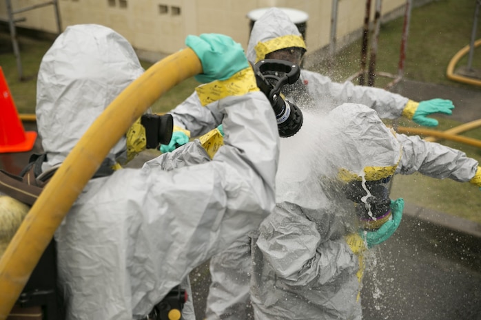 Service members and firefighters practice decontaminating each other during the Hazardous Material Awareness and Operations course at Marine Corps Air Station Iwakuni, Japan, Nov. 19, 2015. This weeklong course gives participants the necessary knowledge and experience they need to be recognized as first responders in a HazMat incident.