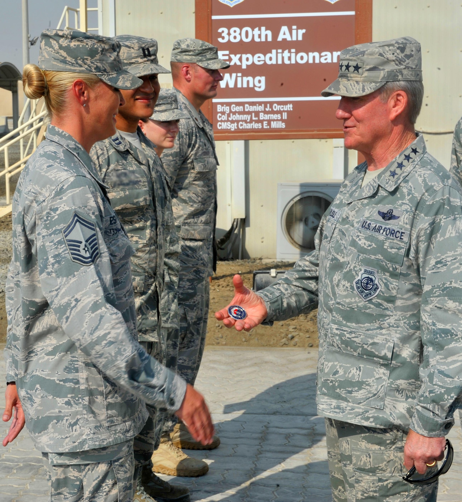 Gen. Hawk Carlisle, commander for Air Combatant Command, presents a commander's coin to Senior Master Sgt. Sarah, Wing Staff Agency superintendent for the 380th Air Expeditionary Wing during a visit to an undisclosed location in Southwest Asia, Oct. 19, 2015. Carlisle's visit was part of an annual tour of the Air Force Central Command area of responsibility to familiarize himself with Department of the Air Force assets.  (U.S. Air Force photo by Staff Sgt. Kentavist Brackin/Released)